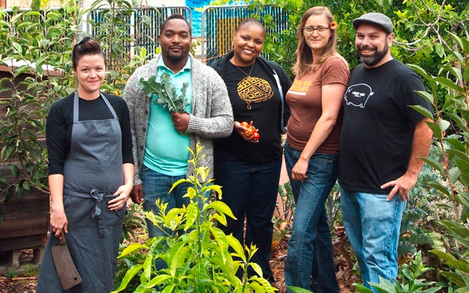 Group photo of people featured, in a garden.