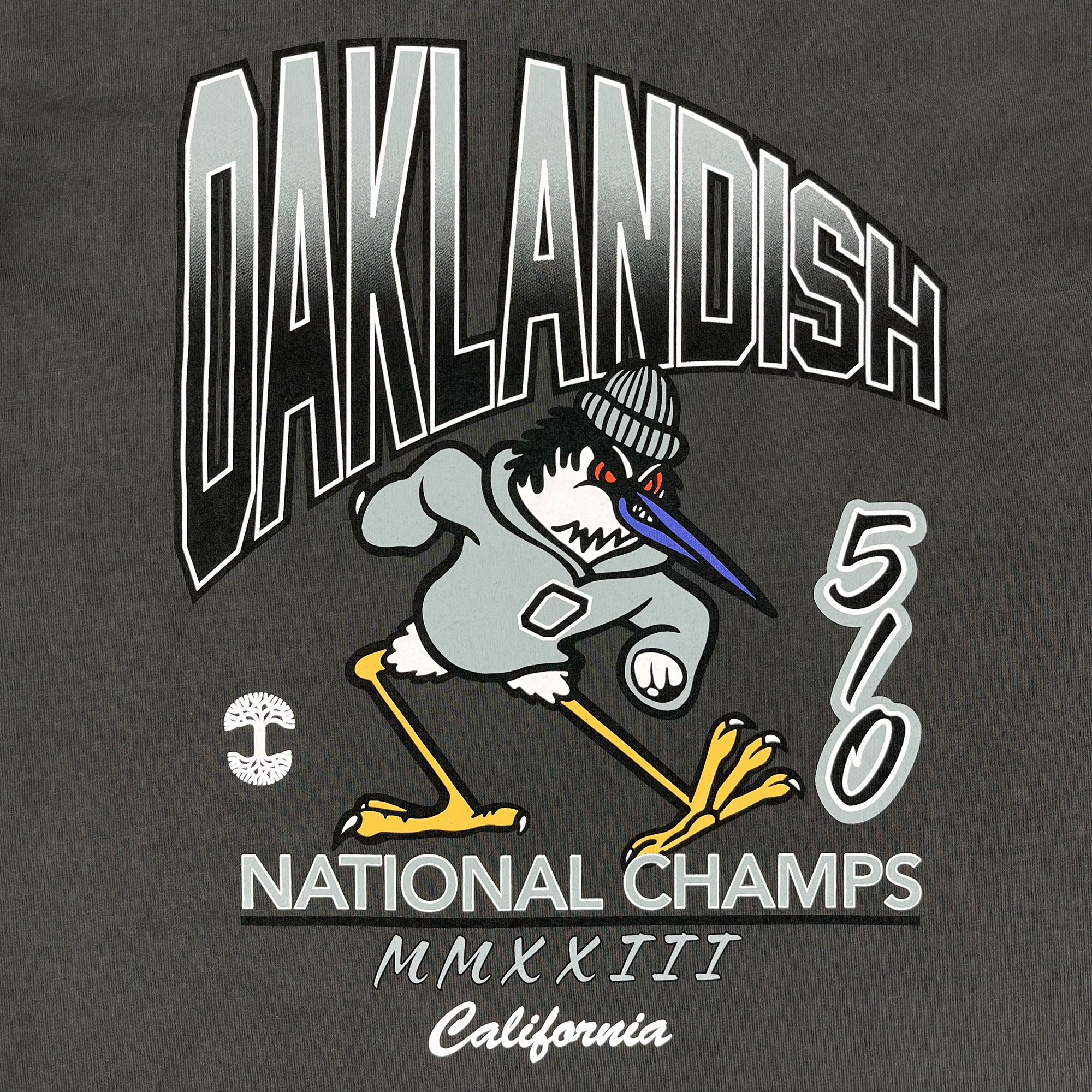 Close-up of OAKLANDISH, 510 NATIONAL CHAMPS wordmarks & natty sports bird on a faded black t-shirt. 