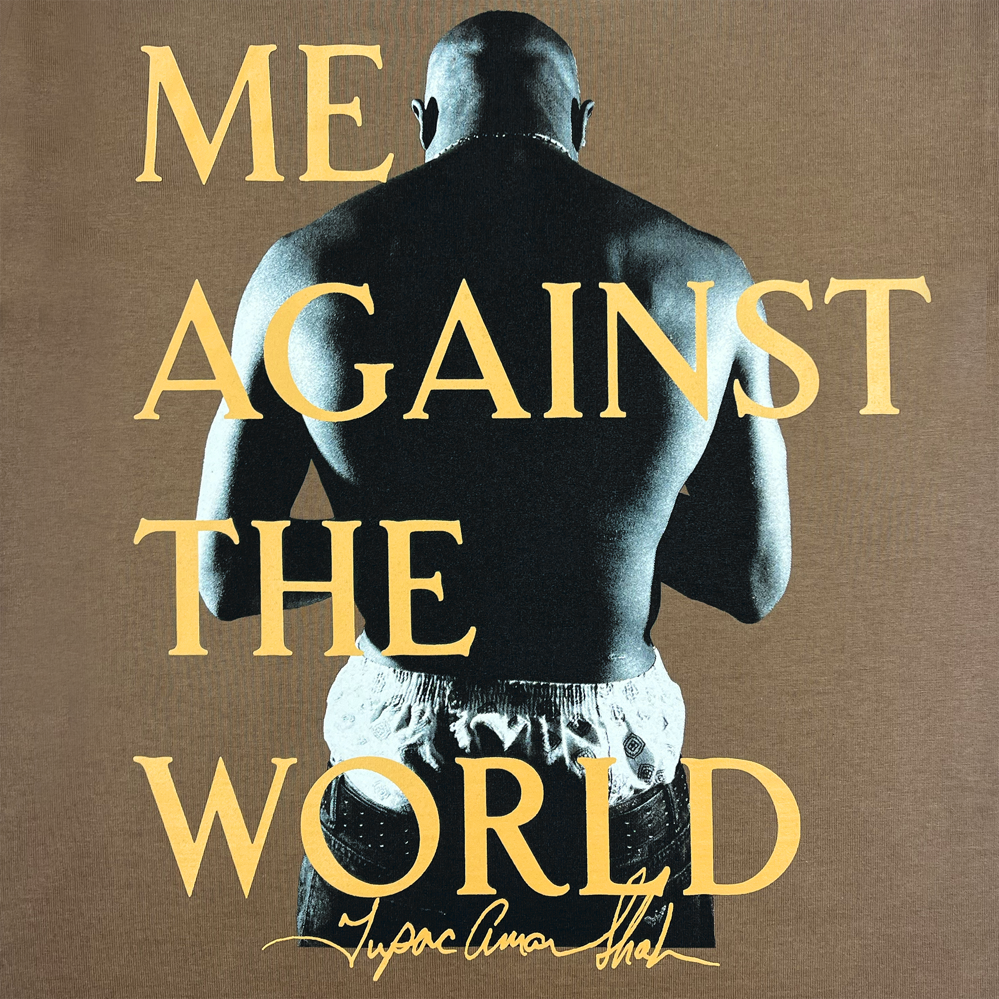 A person with a shaved head stands with their back to the camera, hands together behind their back. They wear shorts, highlighting a muscular build. The words "ME AGAINST THE WORLD" float above them like a Tupac Shakur anthem, reminiscent of the Against the World Tee by Oaklandish. At the bottom is a stylized signature.
