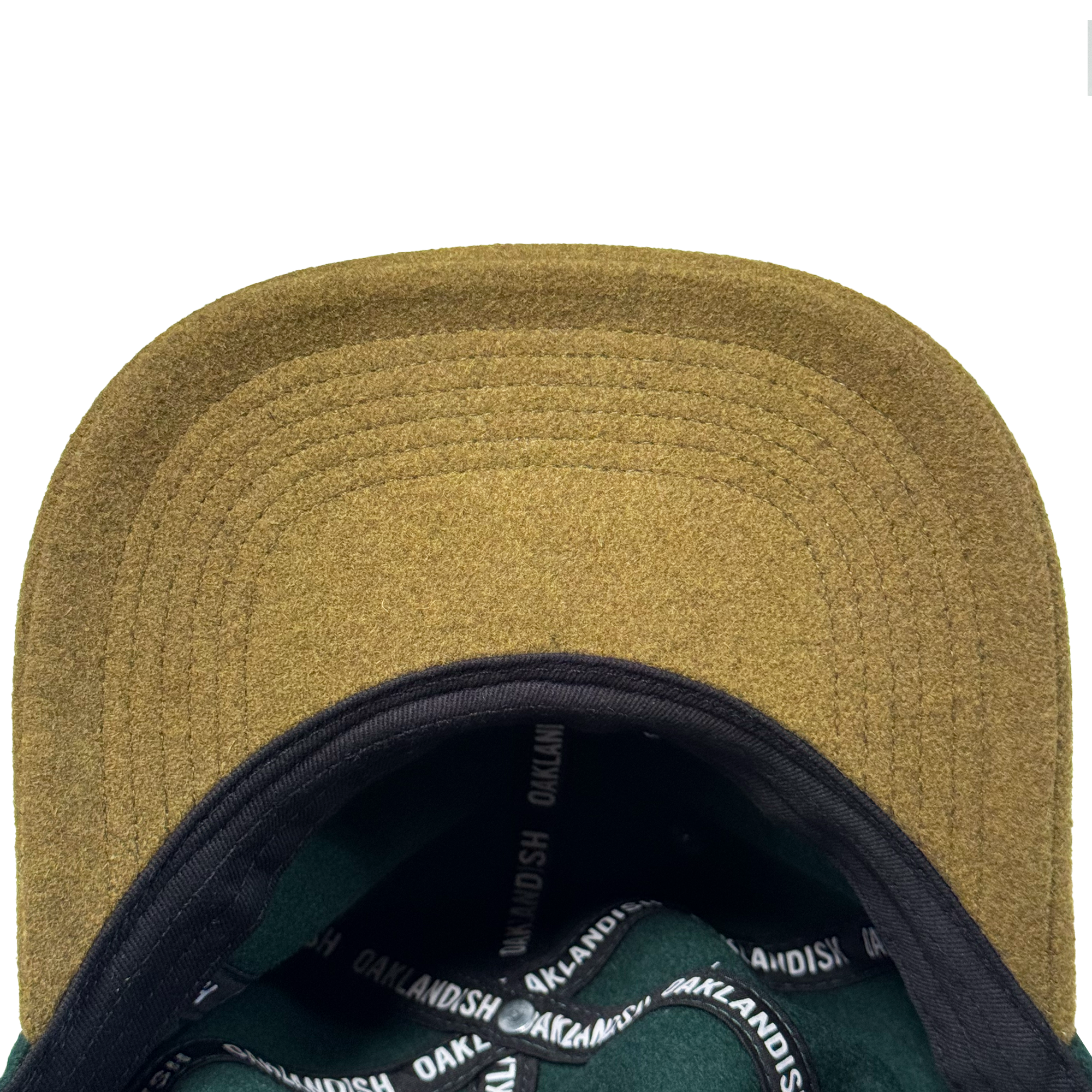 Close-up of the underside of the tan Oakland Ballers B Strapback hat. The black inner band, with repeated white "OAKLANDISH" text, and adjustable strap are clearly visible against a white background. Brand: Oakland Ballers.