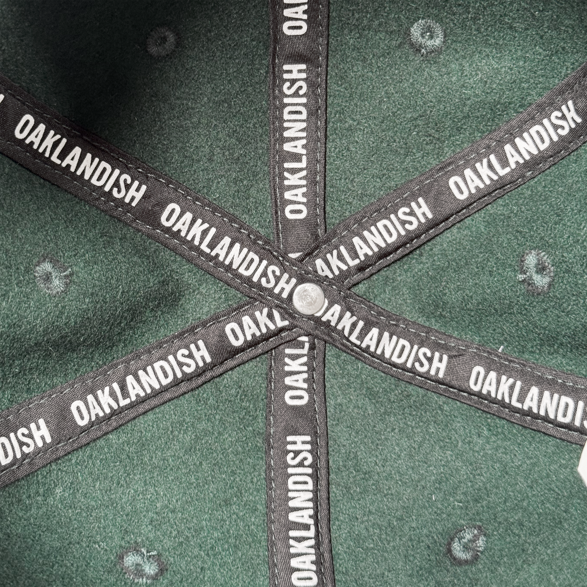 The Oakland Ballers B Strapback hat by Oakland Ballers features a green interior with five black seams labeled "OAKLANDISH" in white, embroidered tree-like designs, and an adjustable strapback for a customizable fit.