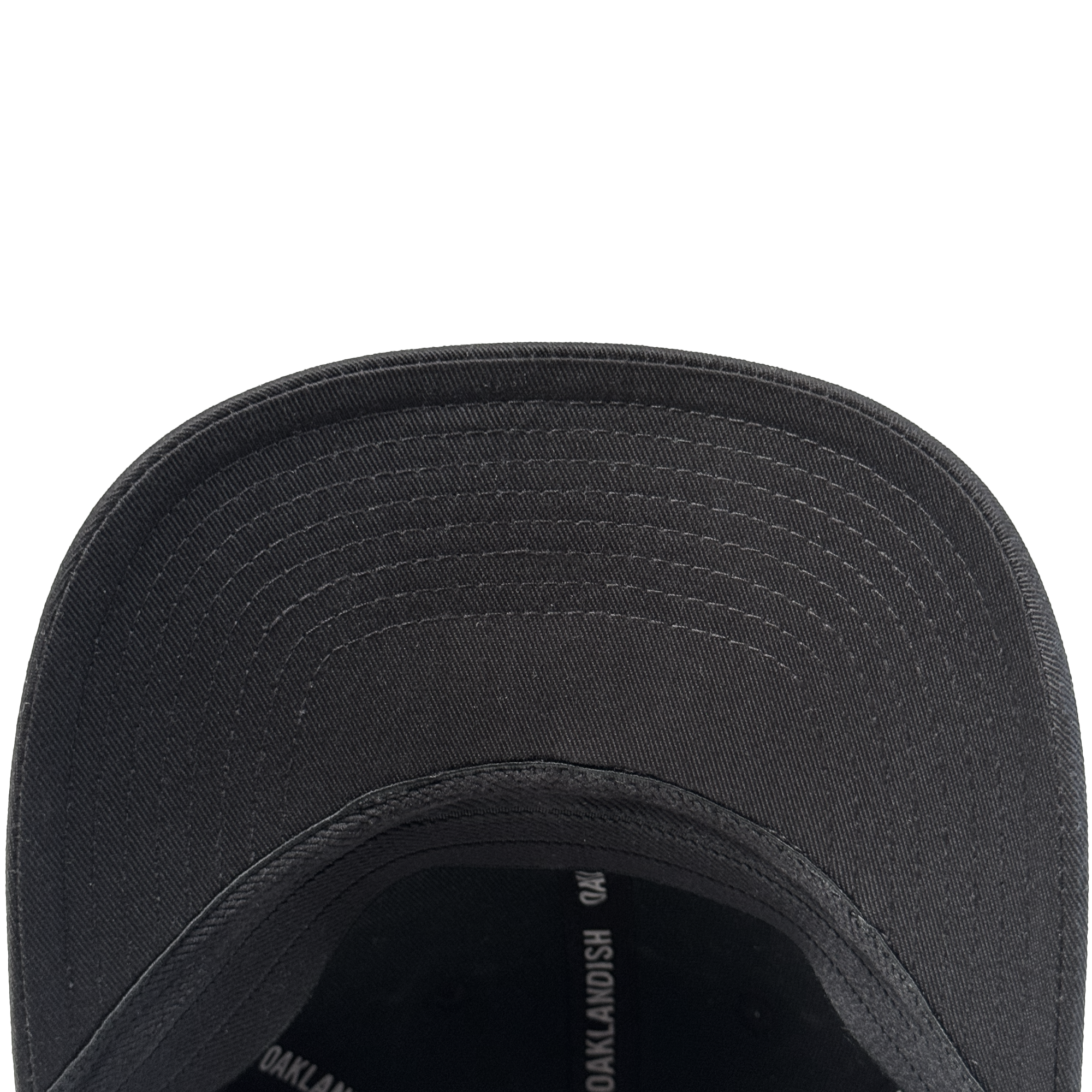 Close-up view of the underside of the Oakland Ballers Flexfit Cap, featuring a curved brim with visible concentric stitching and part of the interior, crafted from durable polyester by Oakland Ballers, with some partially visible printed text.