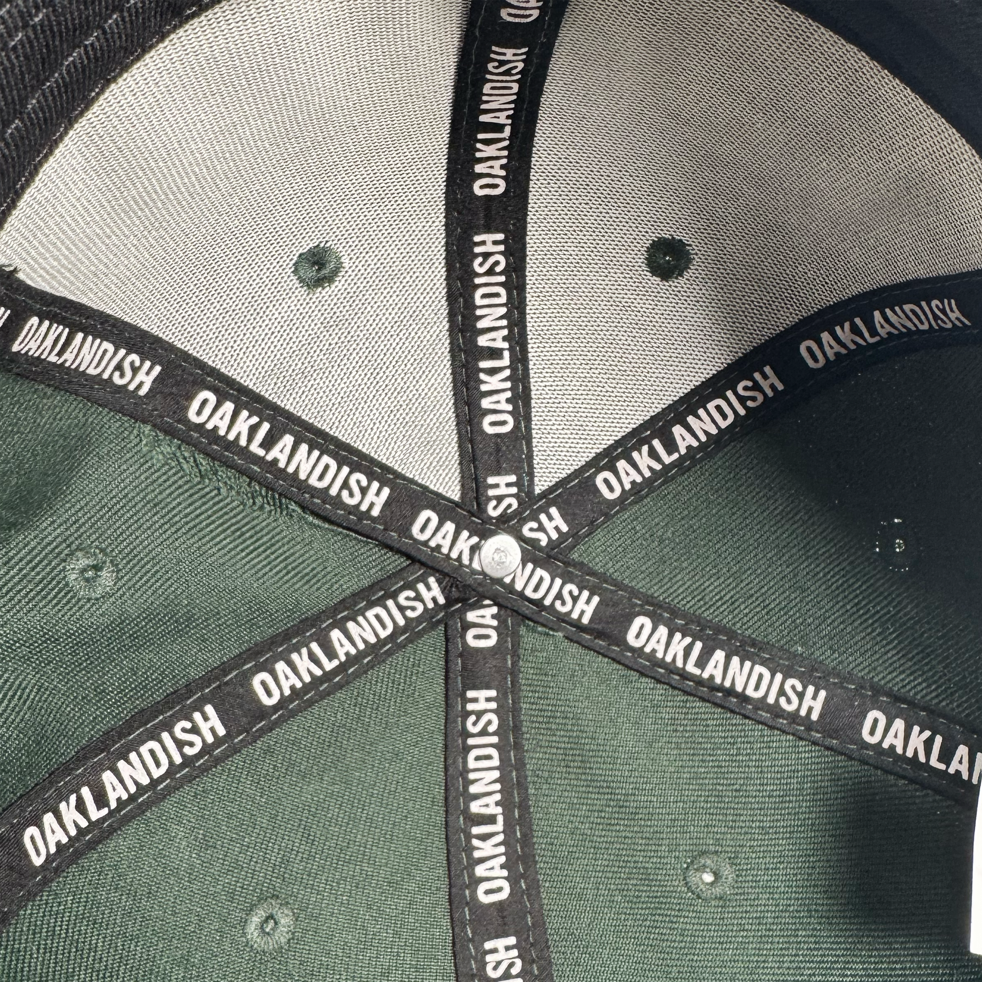 Close-up of the Oakland Ballers Flexfit Cap's inside crown reveals black seam tape with repeating "OAKLANDISH" in white, subtly celebrating the new Oakland Ballers pro baseball team in the Pioneer League.