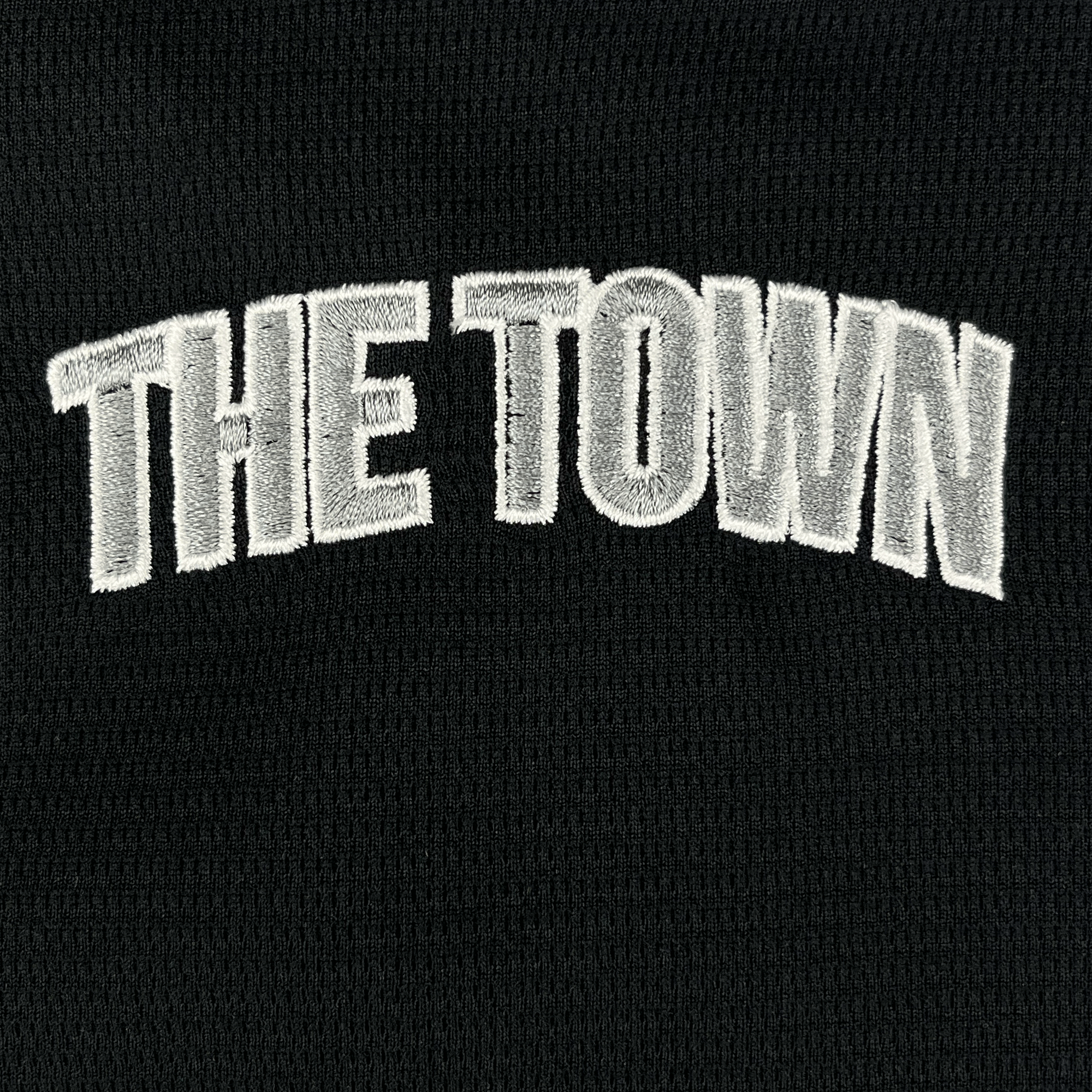 The Oakland Ballers Button Up Jersey features "THE TOWN" embroidered in bold white letters on black fabric, honoring the Oakland Ballers, a Pioneer League pro baseball team, with text arched across the center.