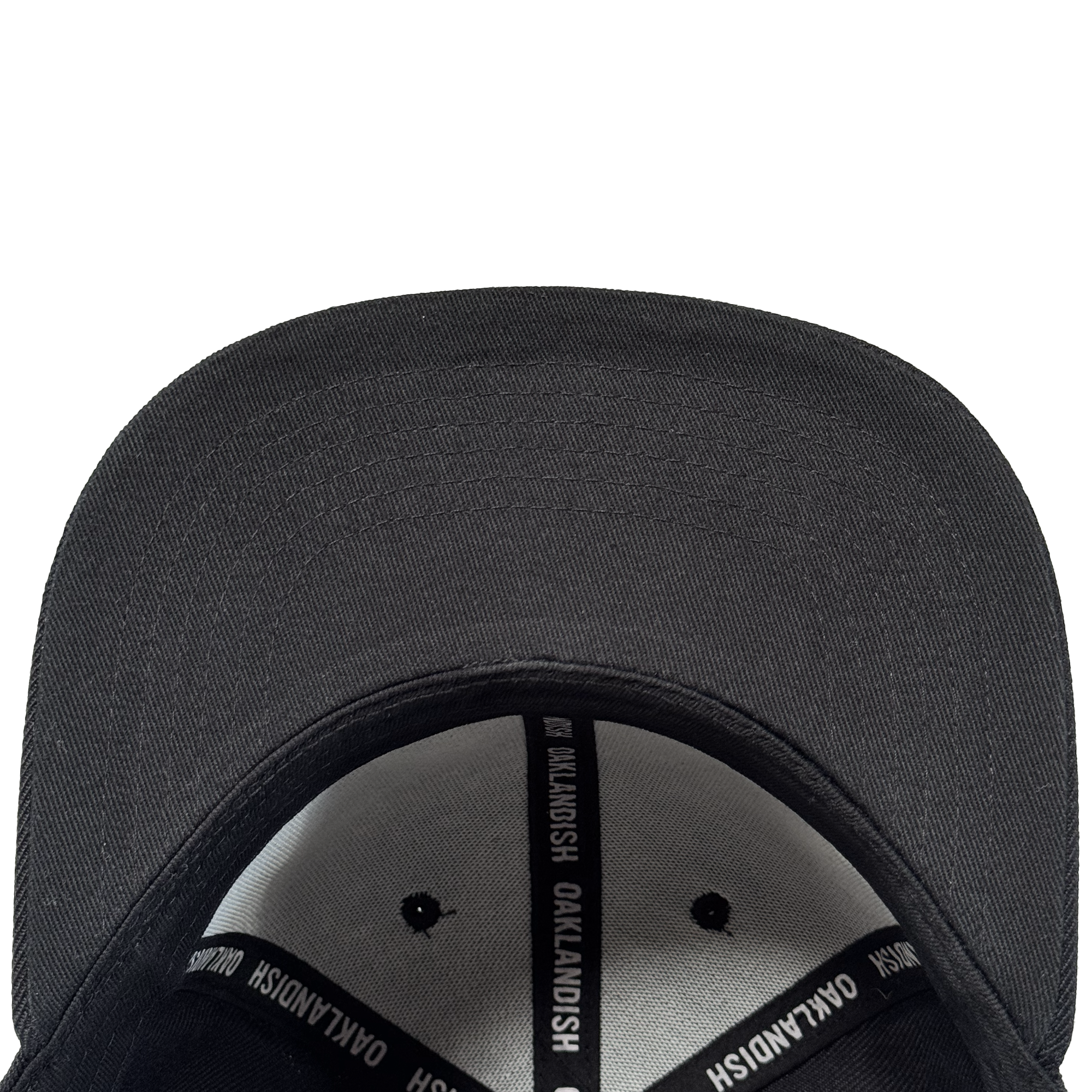 A close-up top-down view of the Oakland Ballers Script Snapback by Oakland Ballers, showing its curved brim and inside band with black and white "OAKLANDISH" labels. The adjustable black hat is set against a plain white background.