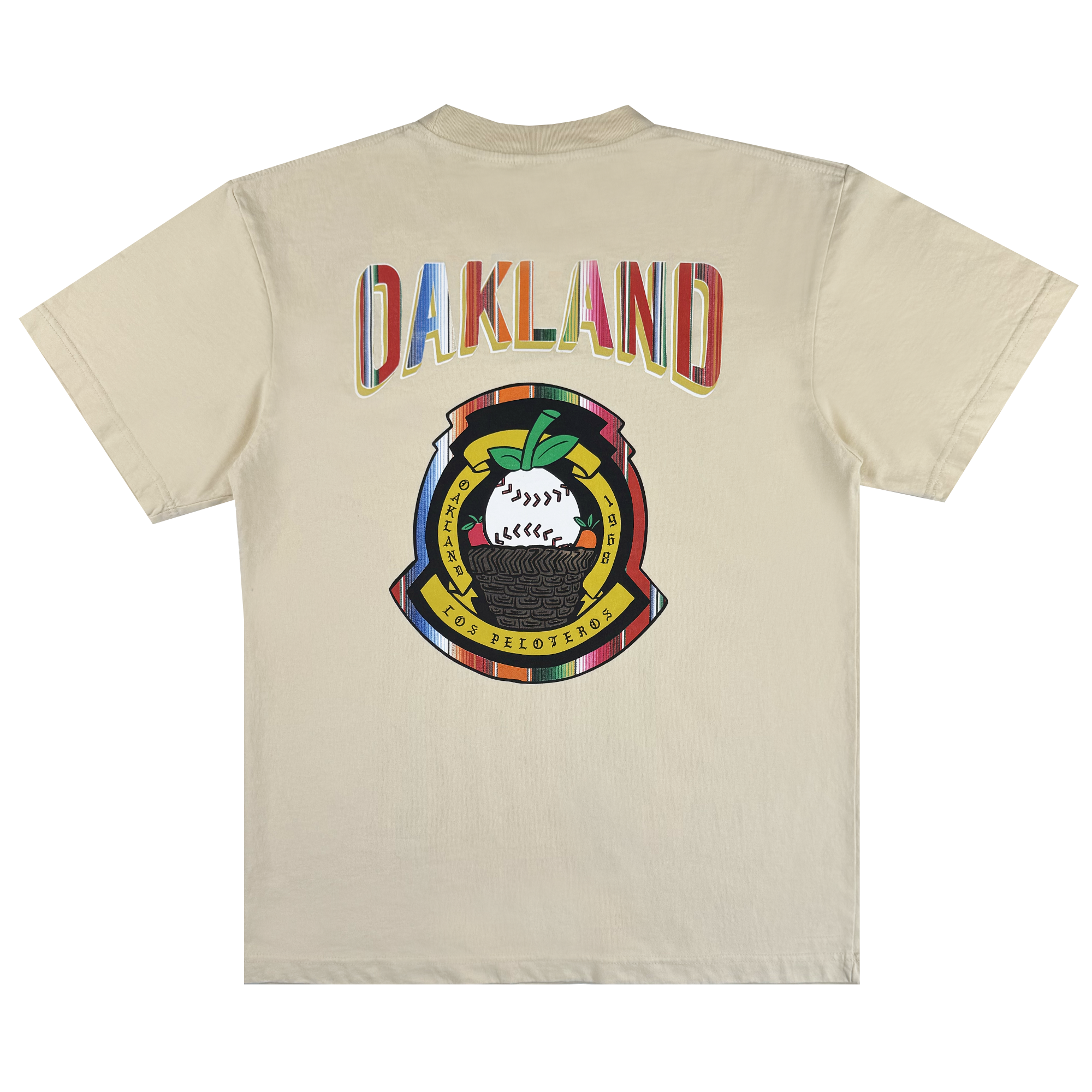 The Oakland Beisbol Tee by Oakland Ballers is a beige shirt featuring "OAKLAND" in bright letters on the back, plus a vibrant emblem with a baseball, green leaves, and "POR LOS PELOTEROS" on yellow and red banners.