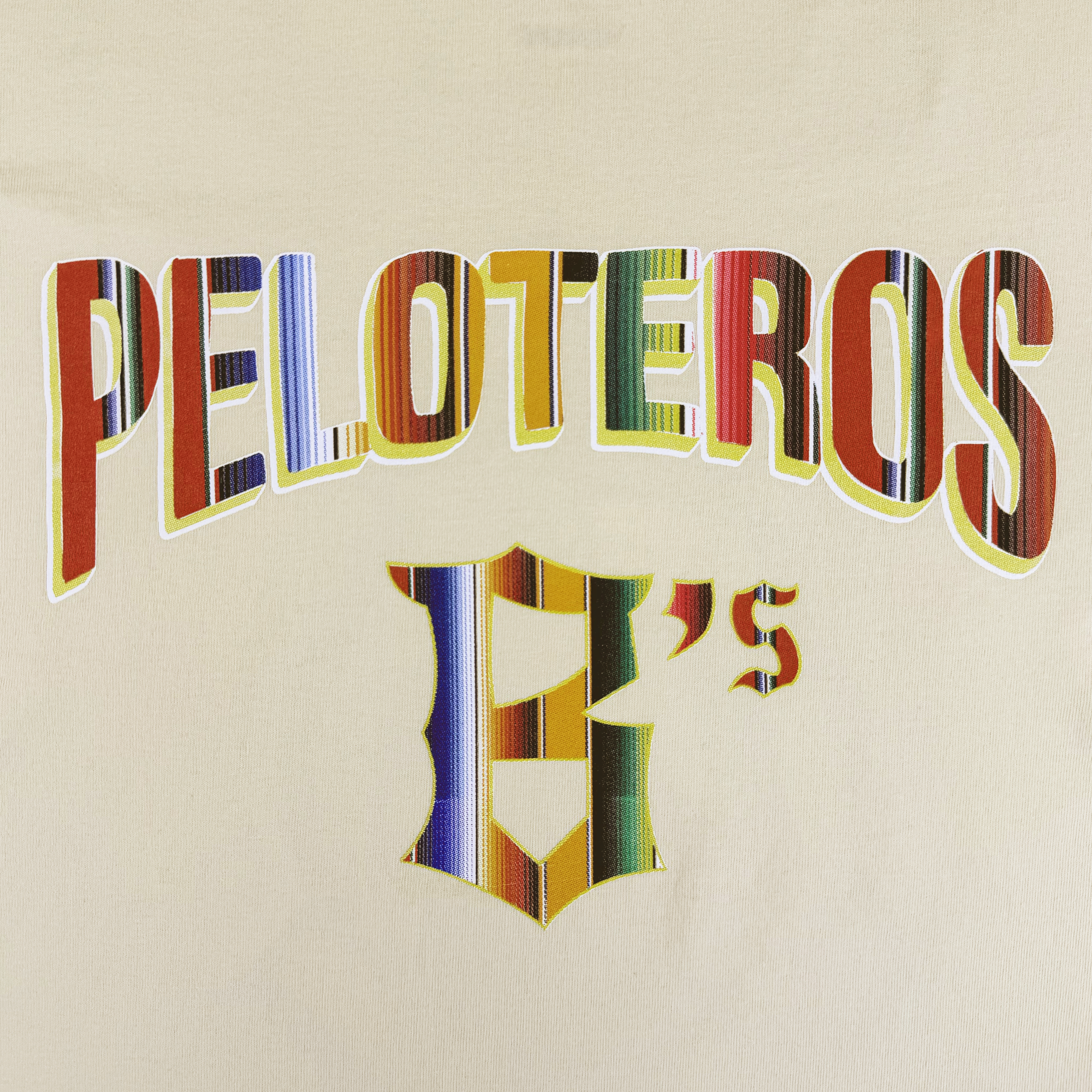 The image features "PELOTEROS" and "B's" in bold, colorful stripes on beige, reflecting the lively Oakland Ballers spirit. Show your team pride with the Oakland Beisbol Tee by Oakland Ballers from the new Pioneer League team.