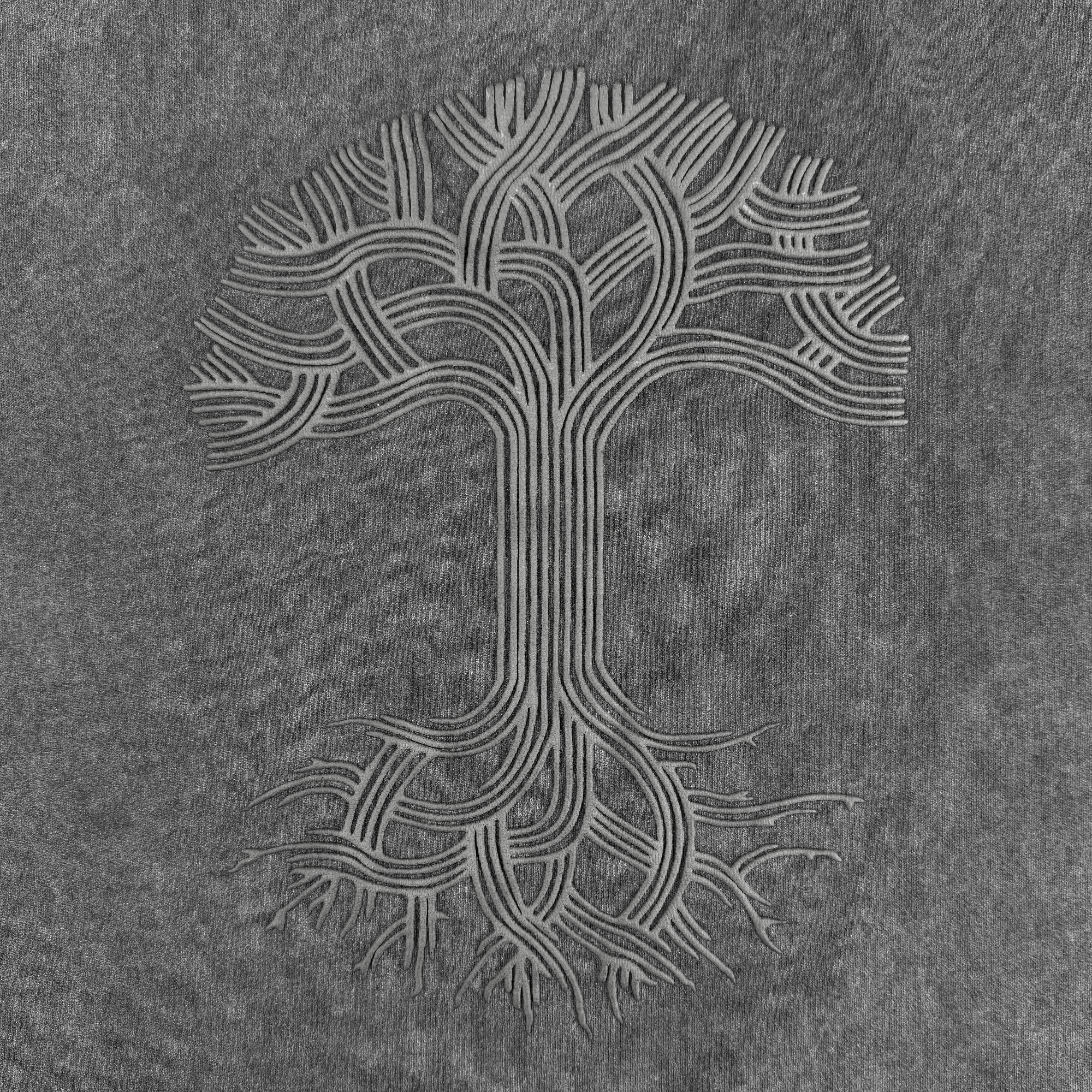 The Oaklandish Classic Logo Tee by Oaklandish features their iconic stylized tree logo with interwoven branches and roots on a faded black heavyweight cotton oversized fit t-shirt for a balanced, abstract look.