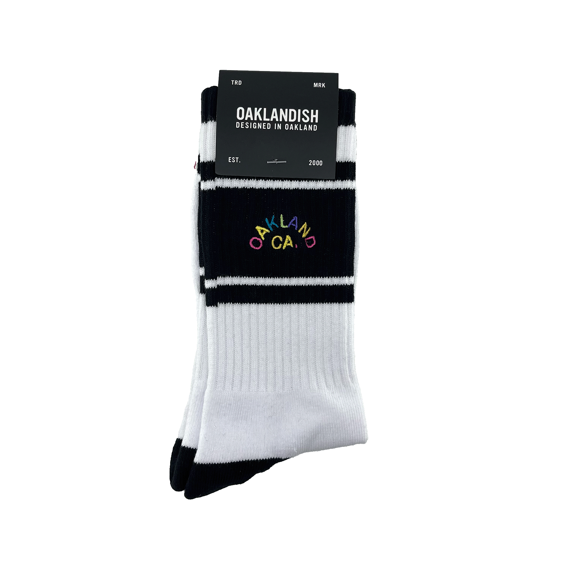 Pair of folded black and white crew socks in Oaklandish packaging with full-color OAKLAND CALIFORNIA wordmark on the sock.
