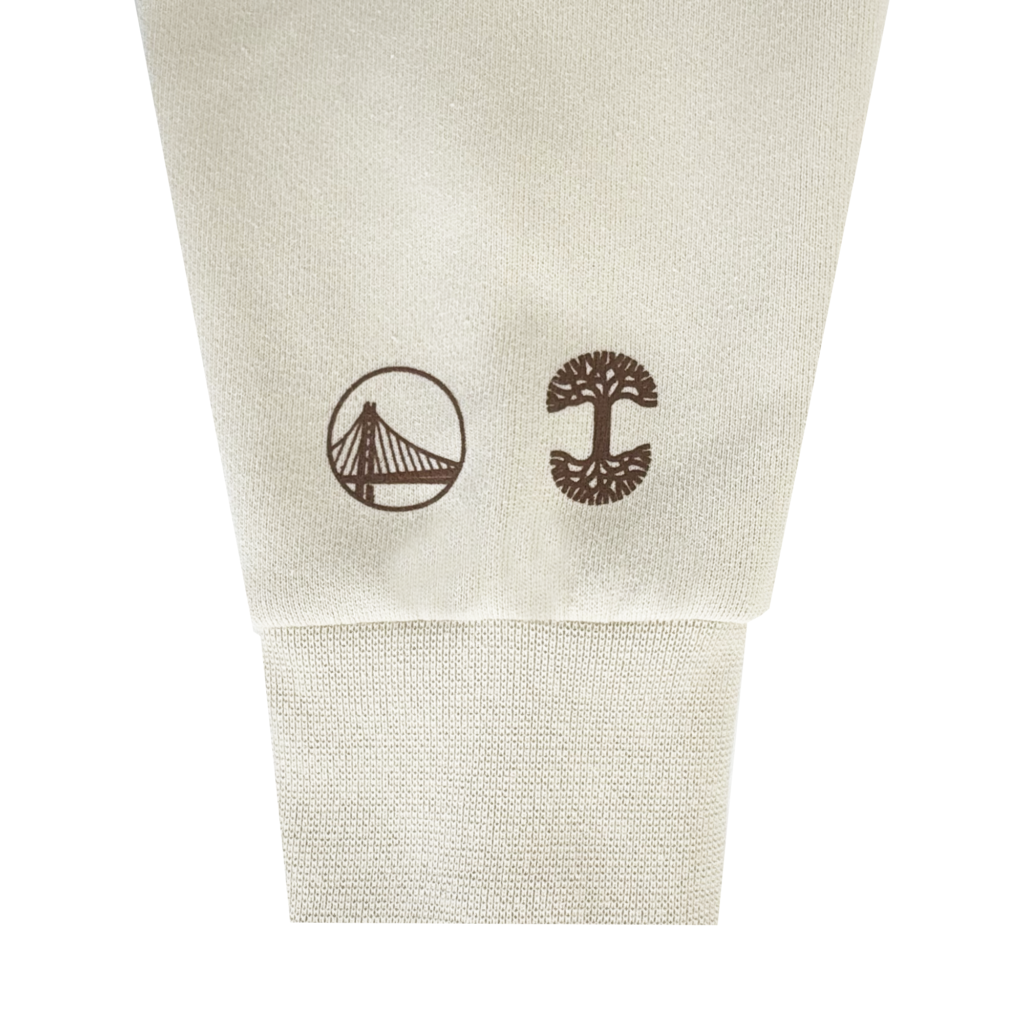 A beige Ghost Block Letters Hoodie by GSW featuring brown graphics: a stylized Warriors bridge in a circle near the left cuff and a symmetrical tree design near the right, both printed close to the ribbed cuffs.