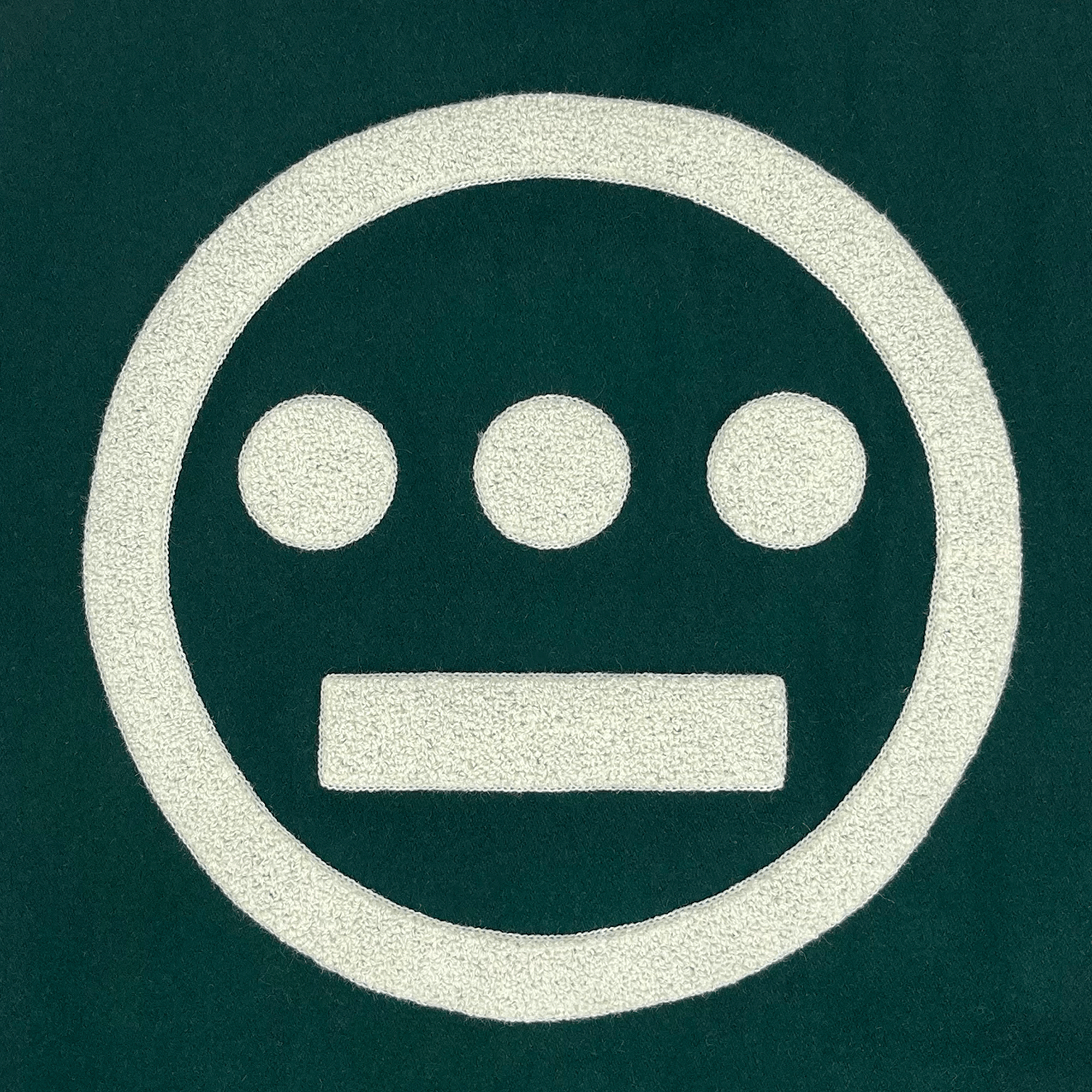 Close-up of a large white 3D Hieroglyphics hip-hop logo on the center back of a green varsity jacket.