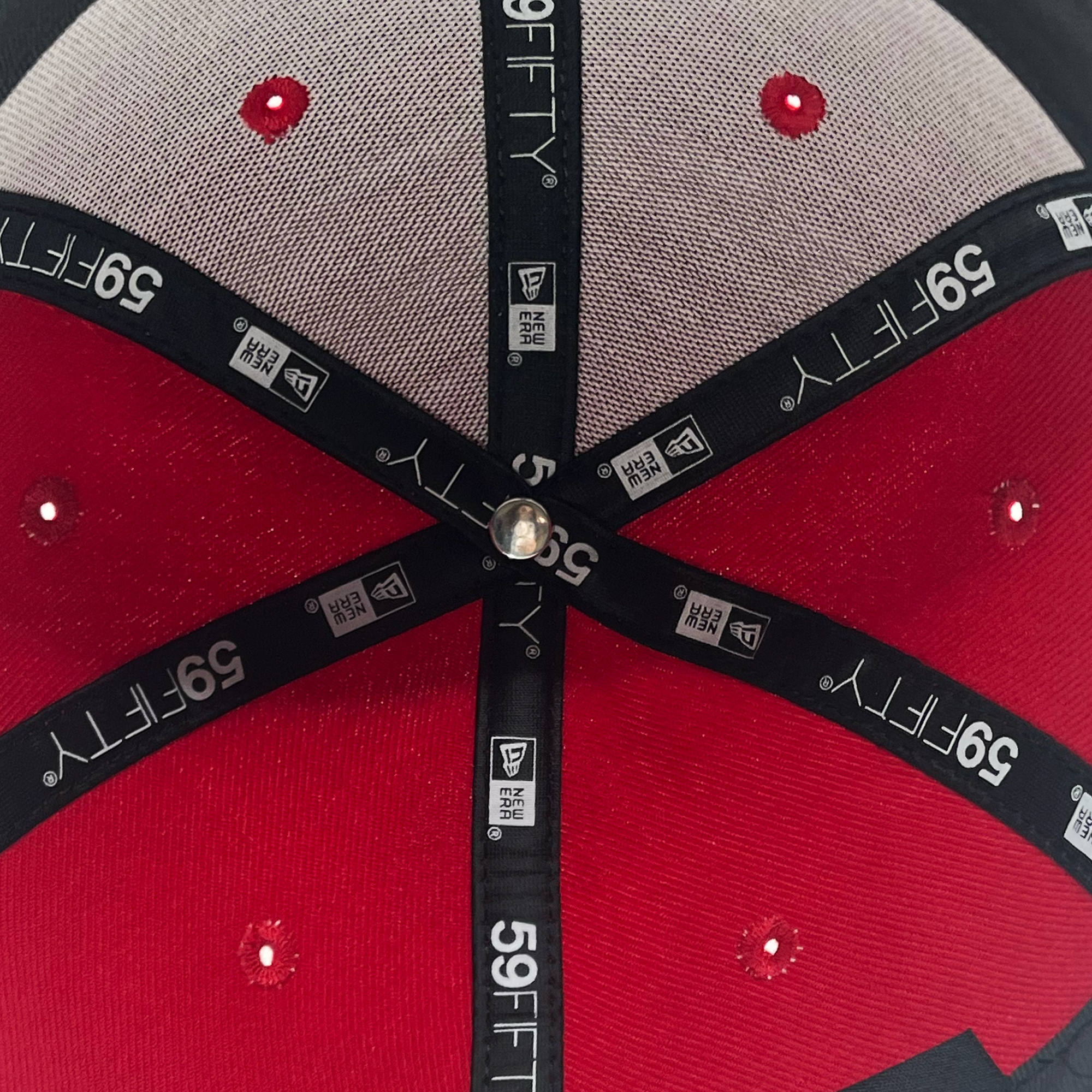 Detailed inside view of red 59fifty fitted hat with 59Fifty and New era logos on taping.