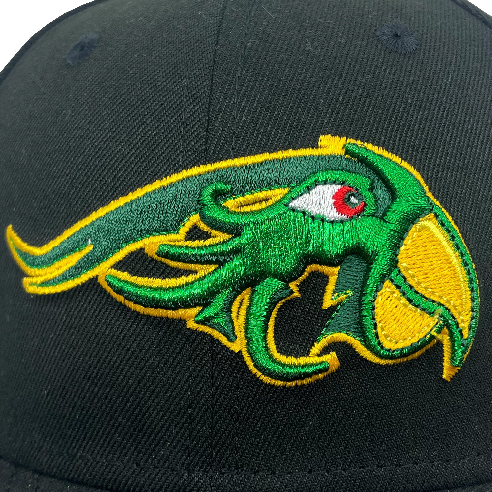 A close-up of the New Era Pericos ALT 59FIFTY Cap from Retail Vendors, showcasing a detailed embroidered logo of a mythical green creature with a large yellow beak, a red eye, and yellow and green tentacles extending from its face. The intricate embroidery displays vibrant colors and precise stitching.