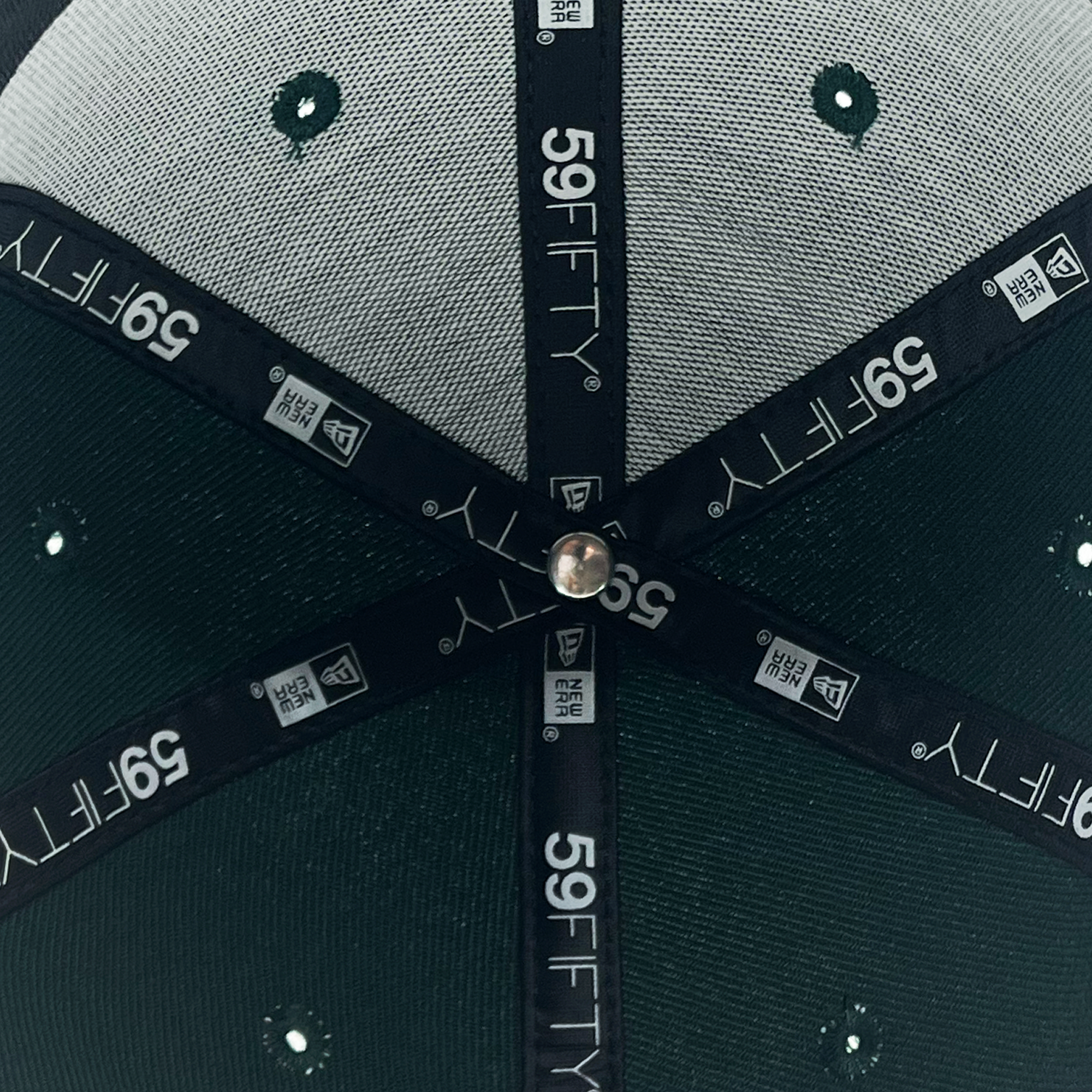 A detailed close-up view of the inside of the top of a New Era Pericos Home 59FIFTY Cap by Retail Vendors. The inner tape seams, labeled "59FIFTY" and featuring the New Era logo, converge at the center button, revealing the green fabric with stitched ventilation holes on the exterior.