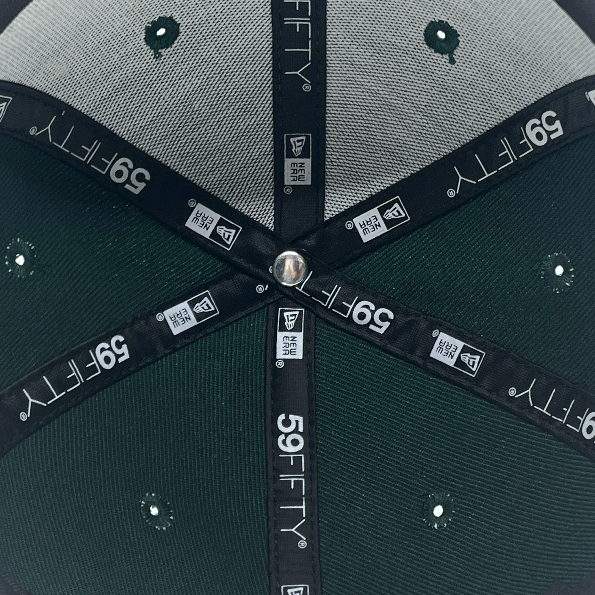 Detailed inside view of forest green Pericos 59fifty fitted hat with 59Fifty and New era logos on taping.