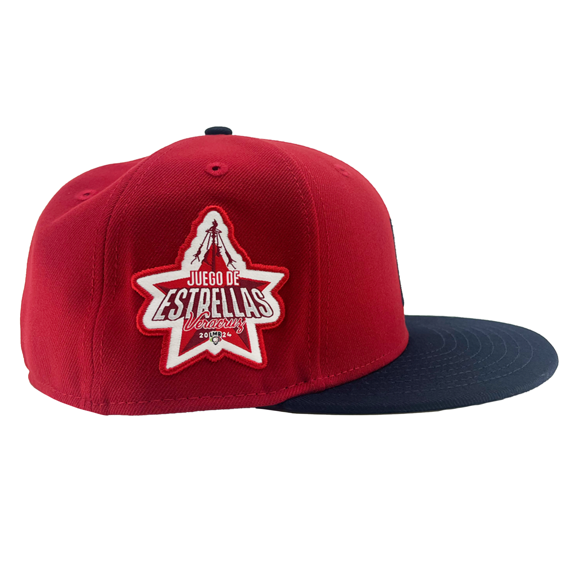 A red and navy New Era El Aguila Alt 59FIFTY fitted baseball cap by Retail Vendors. The cap features a red crown and a navy brim. On the side, there is a large embroidered patch in the shape of a star with text inside that reads "Juego de Estrellas" and "Vancouver". The patch is bordered in white with additional white and red detailing.