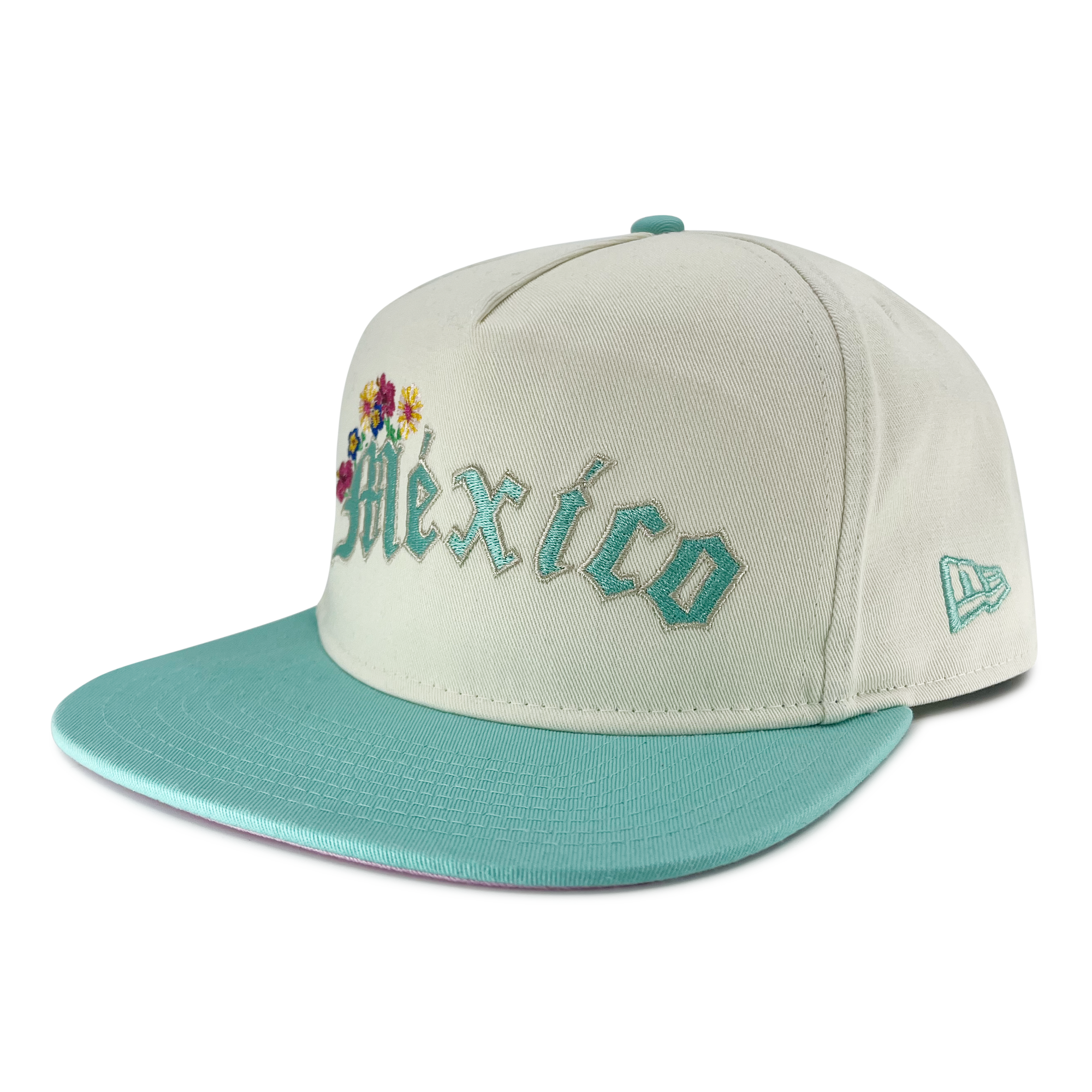 Side view of cream New Era golfer hat with embroidered Mexico and floral design with new era flag on the left wear side.