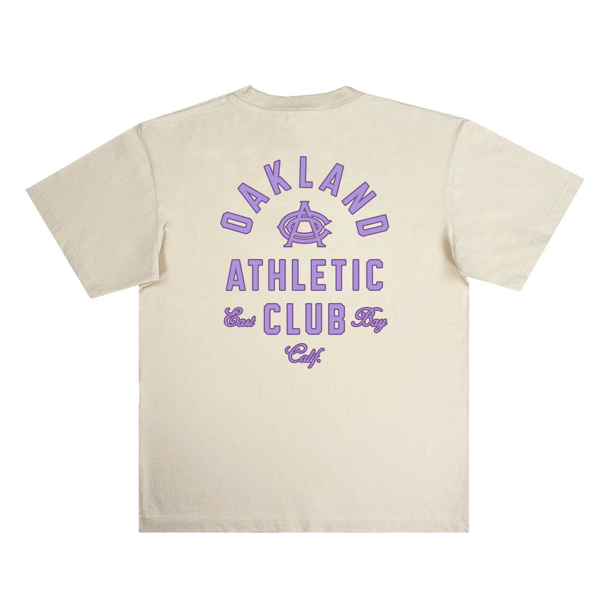The OAC Tee by OAC is a beige, classic-fit t-shirt featuring bold purple text and graphics on the back. The design showcases “OAKLAND ATHLETIC CLUB East Bay Calif” with a stylized “A” logo at the center, all printed on heavyweight cotton for a vintage, athletic look. The shirt is displayed laid flat against a white background.