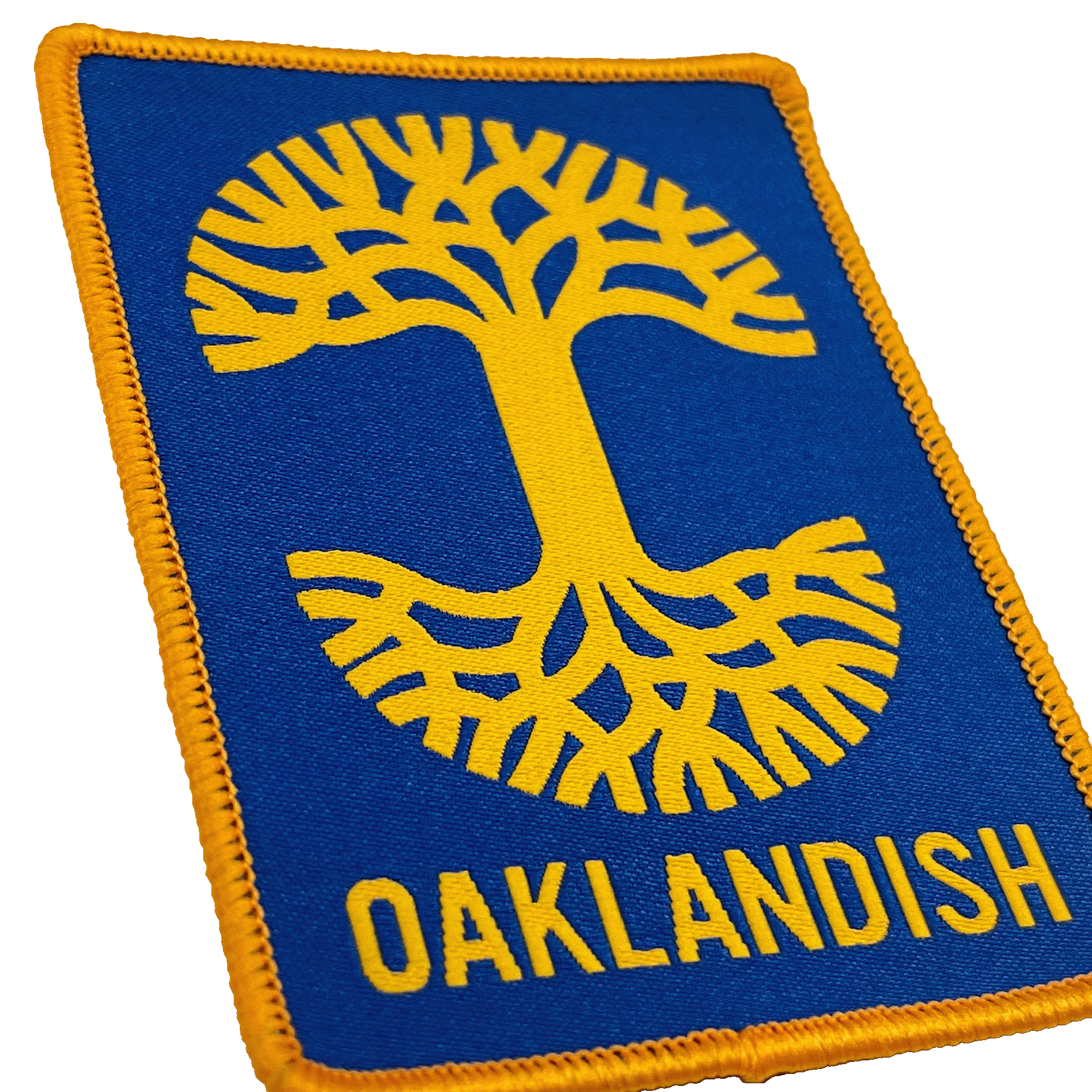 Close-up of royal blue woven iron-on patch with gold Oaklandish tree logo and wordmark.