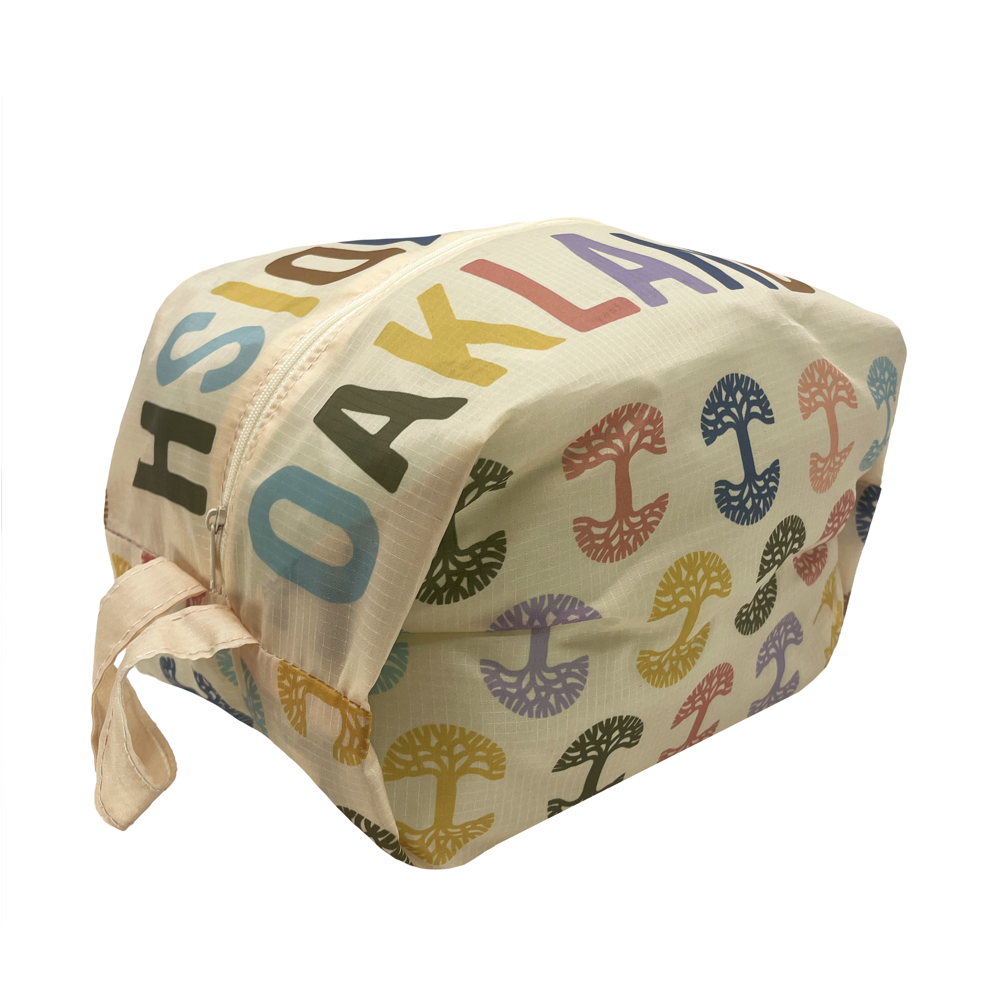 The Repeat Tree Pouch Large - Natural by Oaklandish is a rectangular beige bag with a top zipper, featuring colorful text repeatedly spelling out "OAKLAND" in various fonts. Made from durable ripstop material, the bag includes large pouches and vibrant abstract tree-like designs scattered across it. A short beige strap adorns one side.