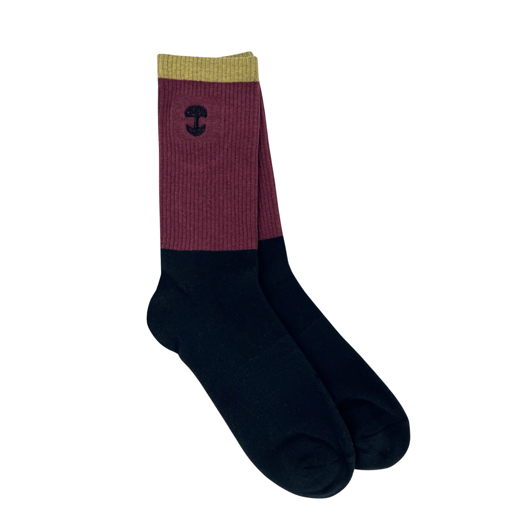 The Oaklandish Colorblock Sock features a unique color block design, with olive green at the top, a maroon middle section, and black covering the lower part. An embroidered Oaklandish logo adorns the maroon portion near the top. The background is plain white.