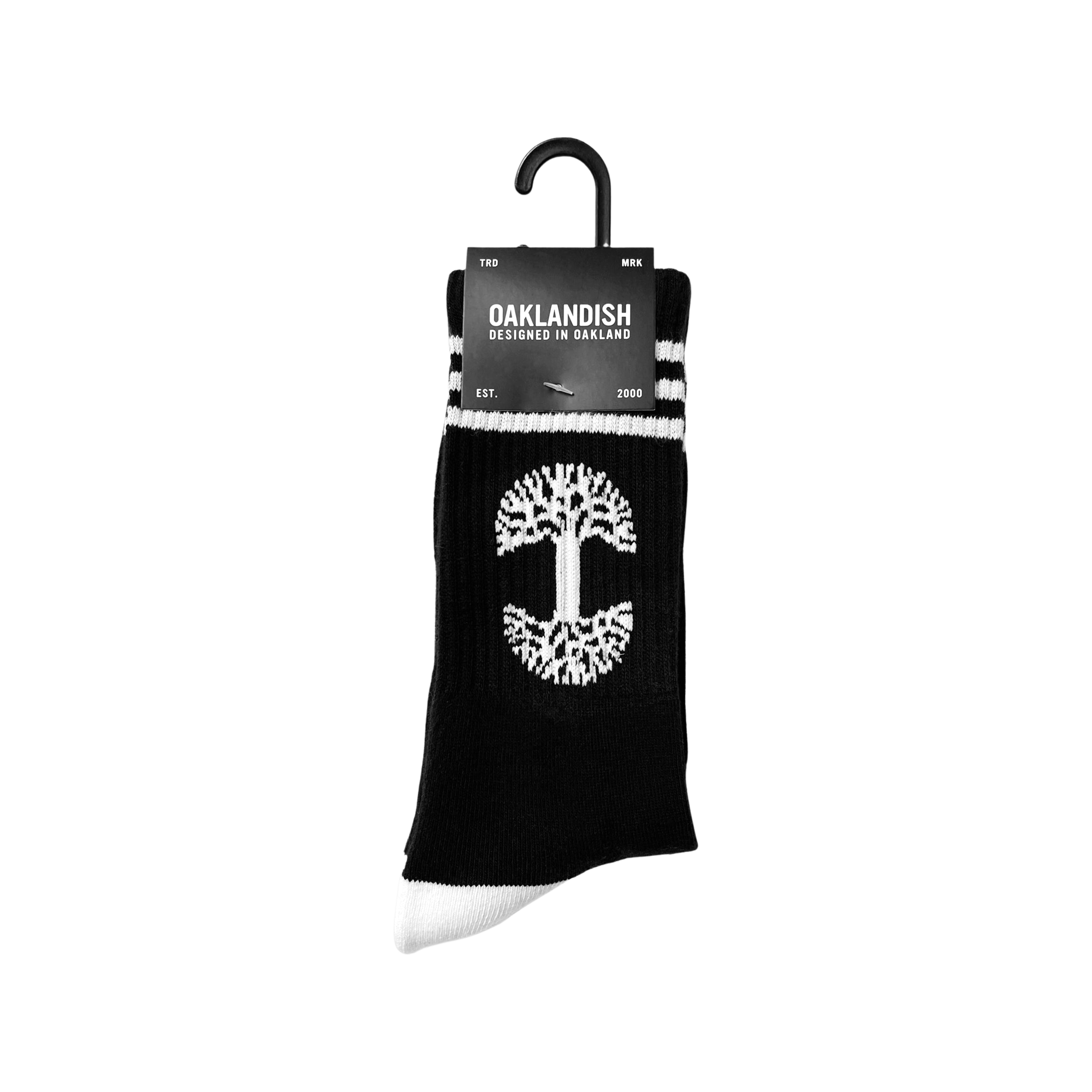 A pair of exceptionally comfy Retro Classic Socks by Oaklandish, featuring a black base with white accents. These socks showcase a white tree symbol in the center, white toes, and two white stripes near the top. The packaging label proudly displays "Oaklandish," along with "Designed in Oakland" and "EST. 2000.