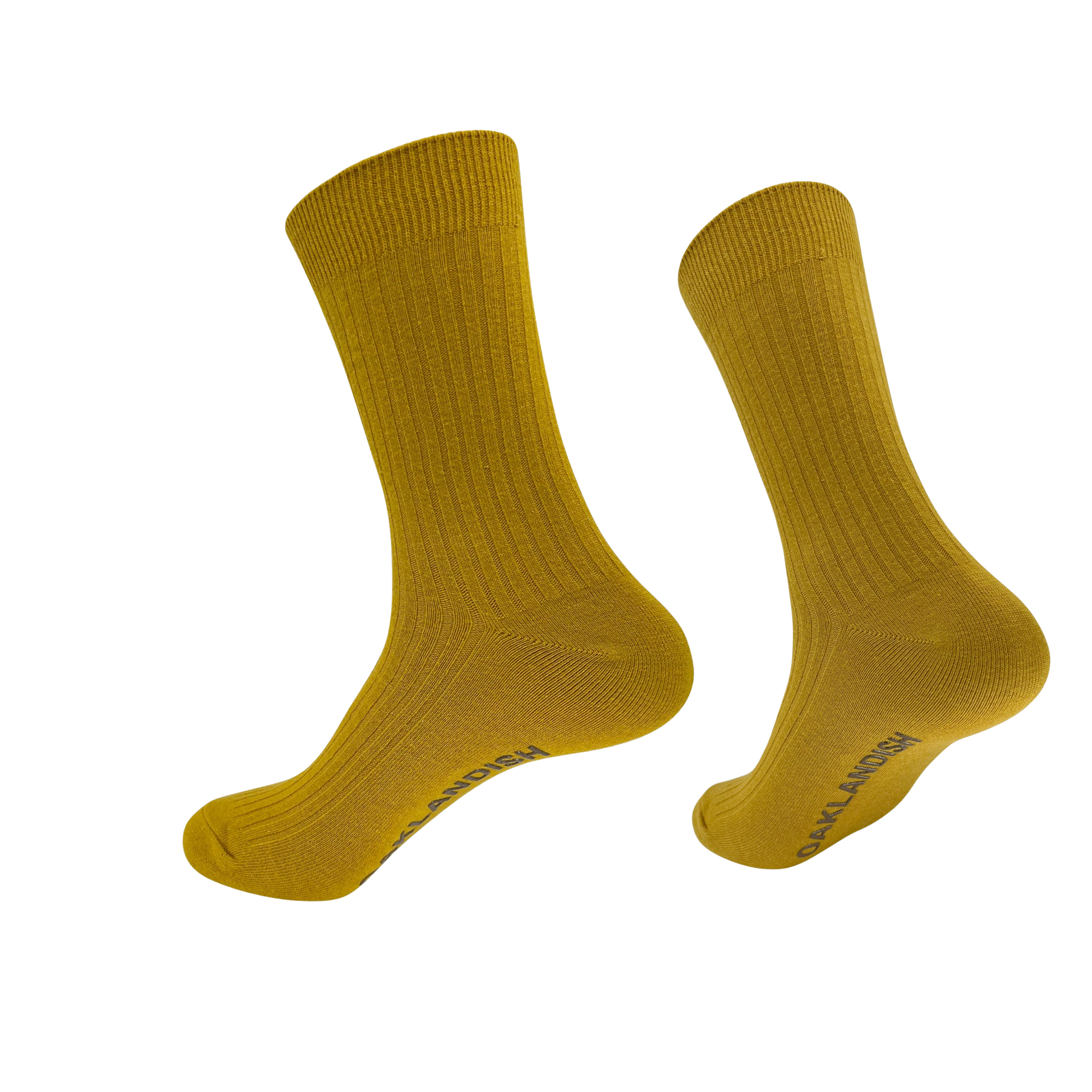 A pair of mustard-yellow Oaklandish Grip Crew Socks are displayed against a plain white background. These cotton polyester spandex socks feature a ribbed texture and mid-calf length, with "SAY HI SOCKS" written on one sole in dark lettering. Both yellow accessories appear to be slightly elevated and angled as if floating.