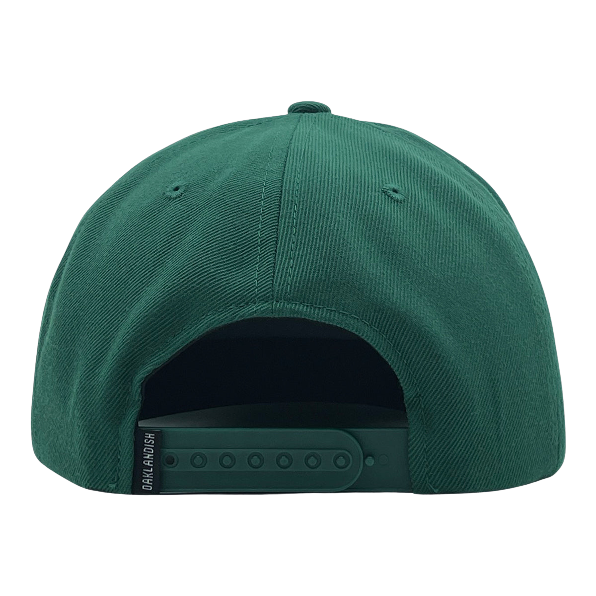 The Oaklandish Classic Snapback, a green baseball cap viewed from the back, showcases its stylish design with an adjustable snapback closure offering multiple size settings. The Oaklandish logo is printed in white on a small black tag located on the left side of the snap. The fabric of the cap features a slightly textured appearance.