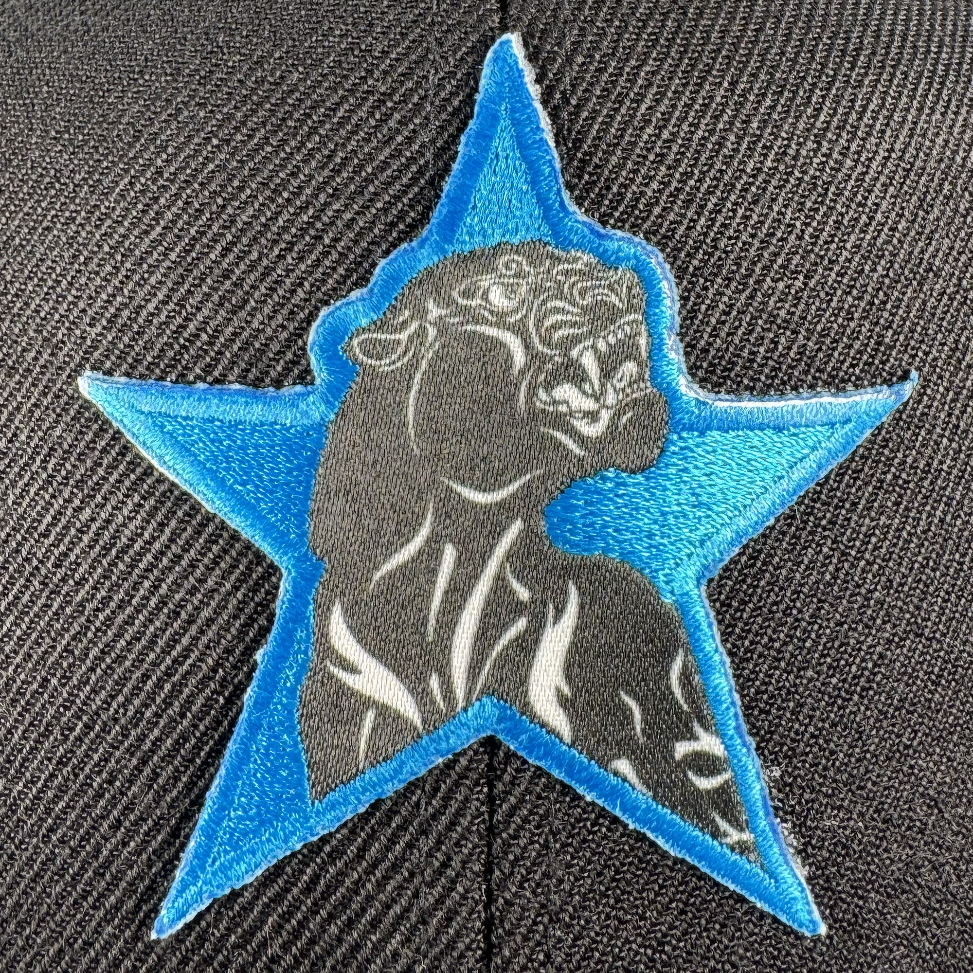 The Power of the People Snapback by Oaklandish features a roaring big cat patch in black and white, stitched inside a bold blue star on textured black fabric—an eye-catching nod to social consciousness.