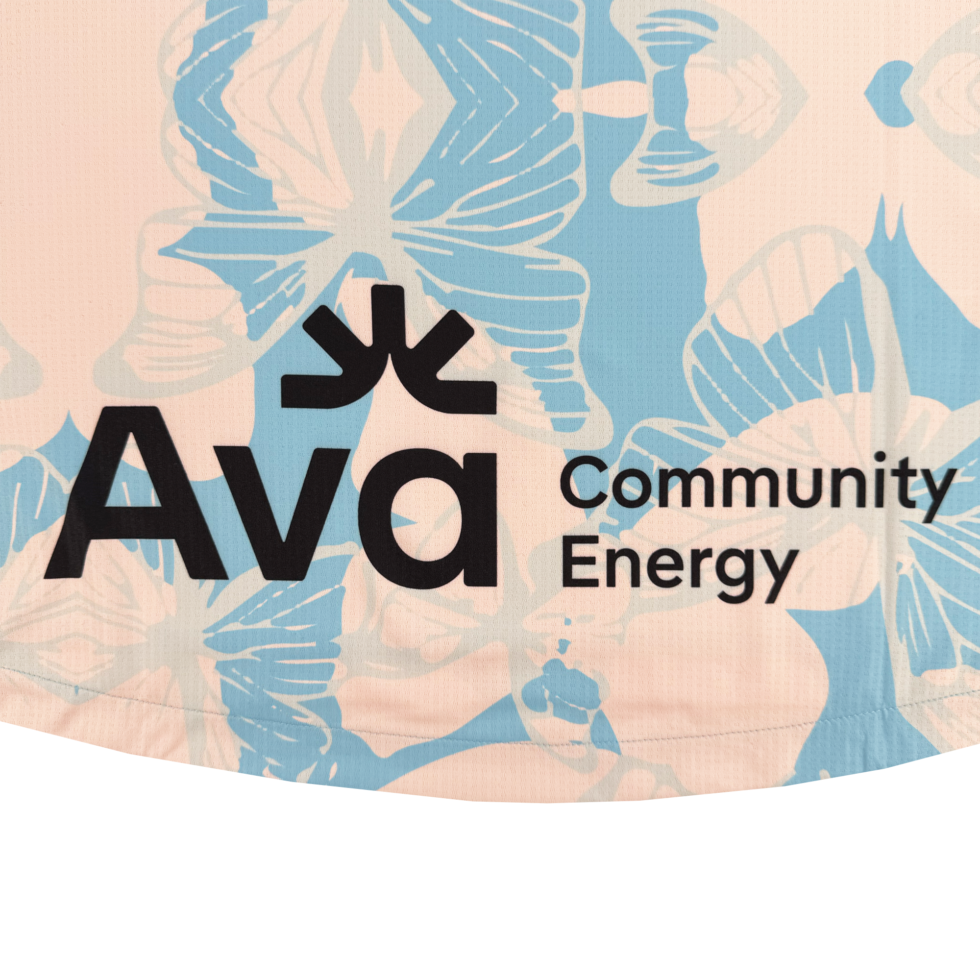 Close-up of fabric from the Unisex Butterfly Effect Kit by Oakland Soul, featuring pastel blue butterflies and floral patterns on light peach. "Ava Community Energy" in black text appears, with a logo above the "v," reflecting Oakland roots and style.