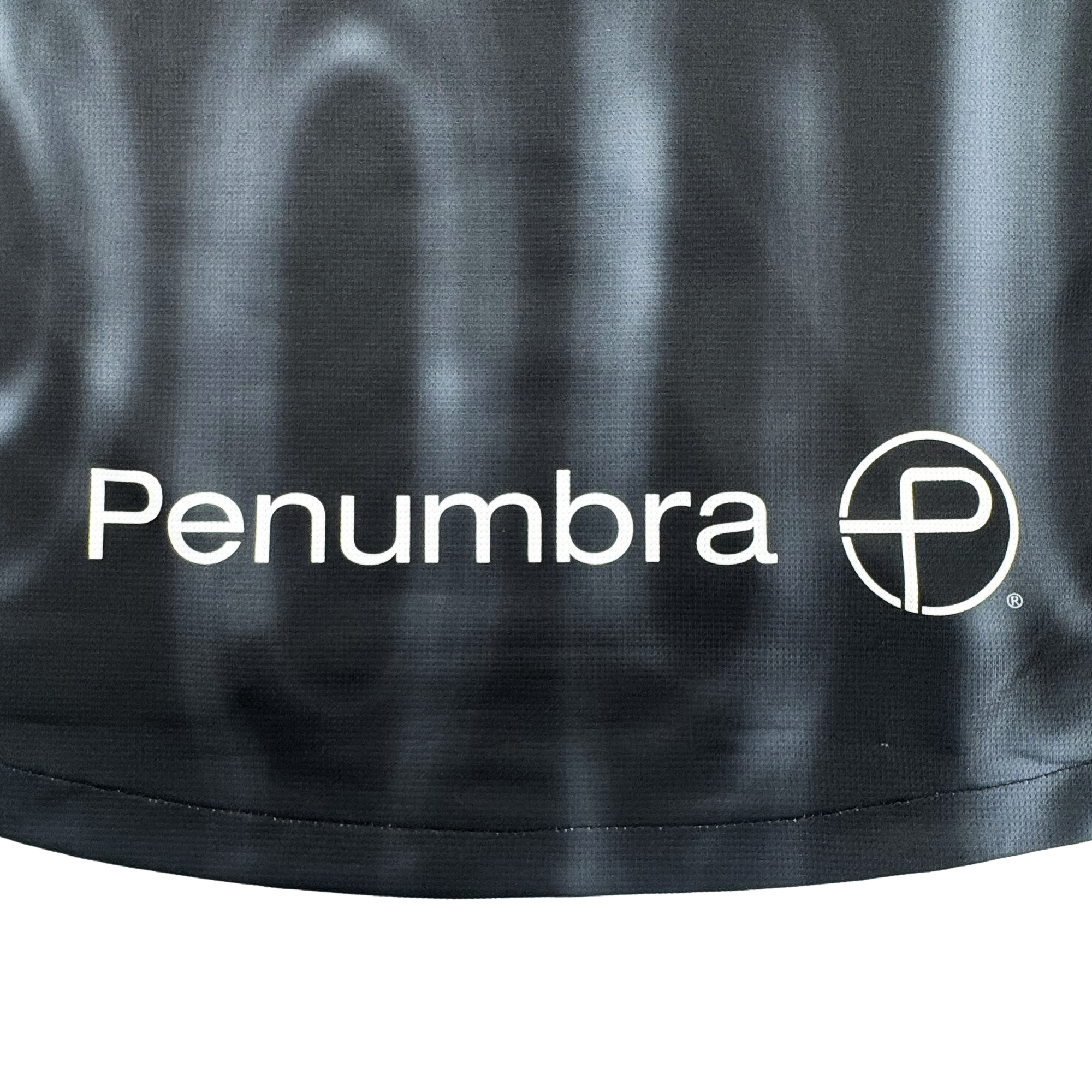 The 2026 Oakland Soul SC Spirit Jersey by Oakland Soul features a black polyester background with "Penumbra" in white and a stylized "P" circular logo, accented by a subtle wavy pattern and visible bottom edge for a classic jersey look.