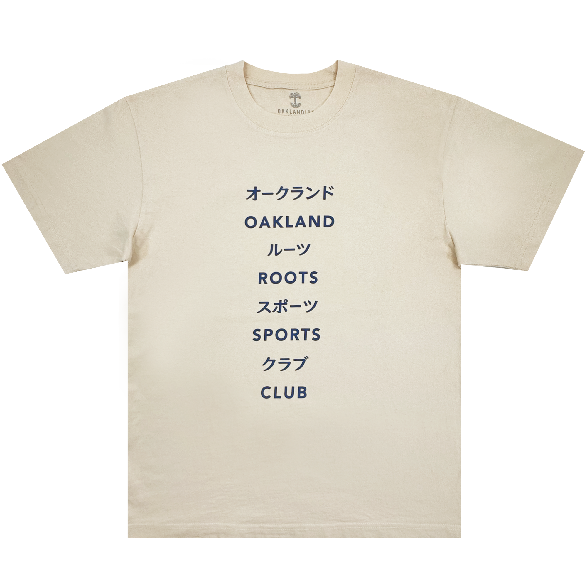 The Story Telling Tee by Oakland Roots SC is a cream tee featuring bold navy text, with alternating Japanese katakana and English on the chest: “オークランド OAKLAND ルーツ ROOTS SC スポーツ SPORTS クラブ CLUB.”.