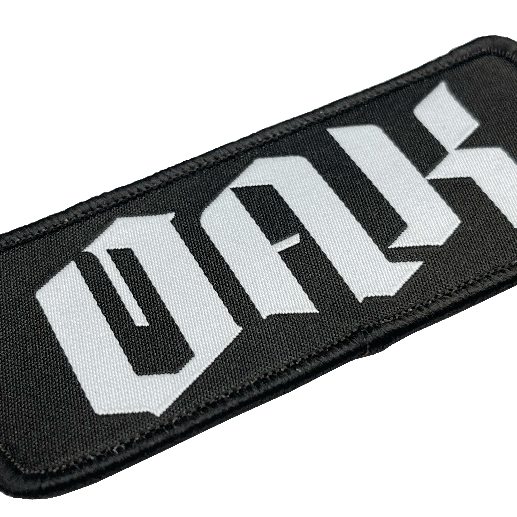 A close-up of the OAK Official Patch by Oaklandish, featuring a rectangular black embroidered design with the words "OAK with the drip" in large, stylized white letters. The letters boast a gothic, angular design and the patch's edges are neatly sewn with black thread. The background is plain white.