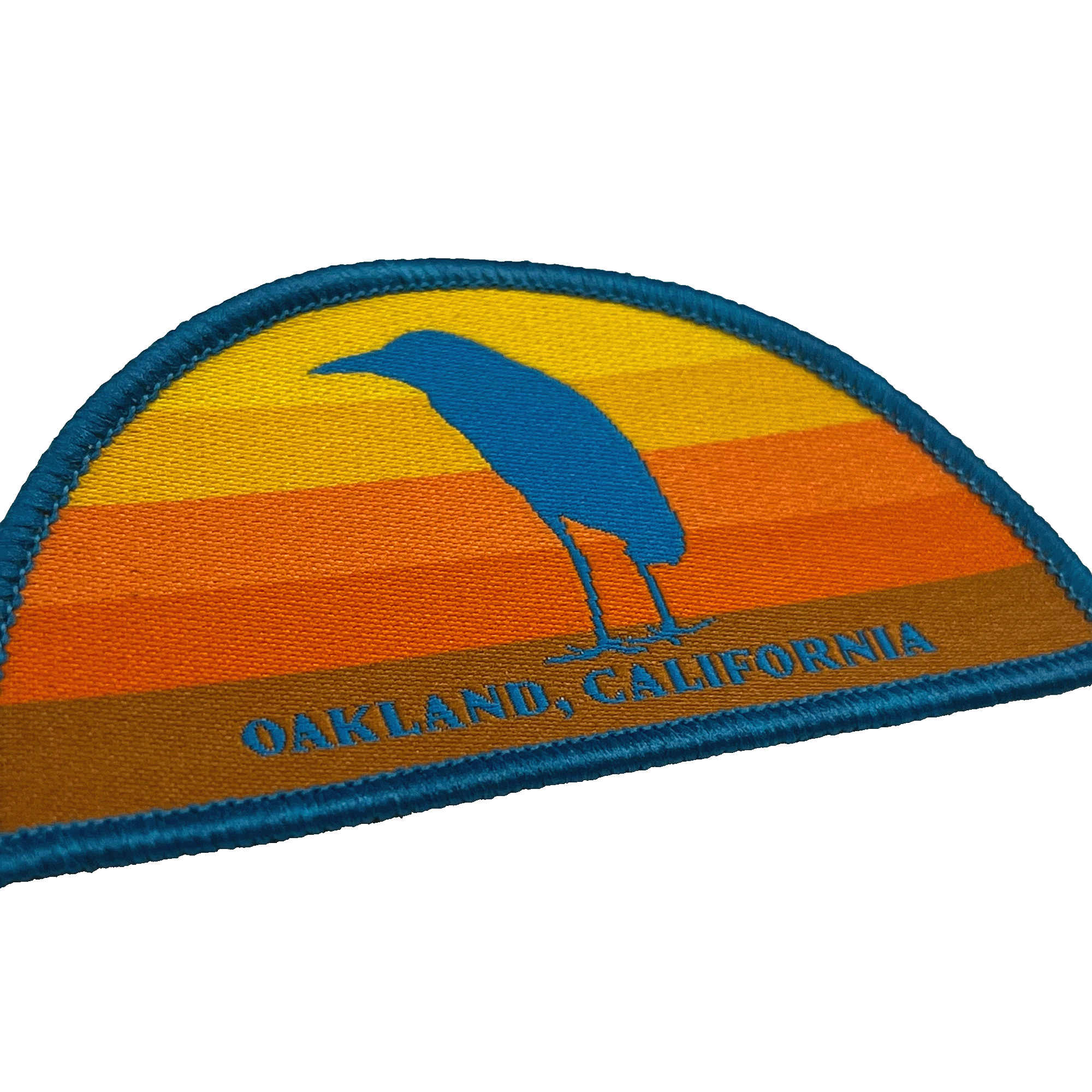 Close-up of multi-color iron-on half circle patch with night heron at sunset with Oakland, California wordmark.