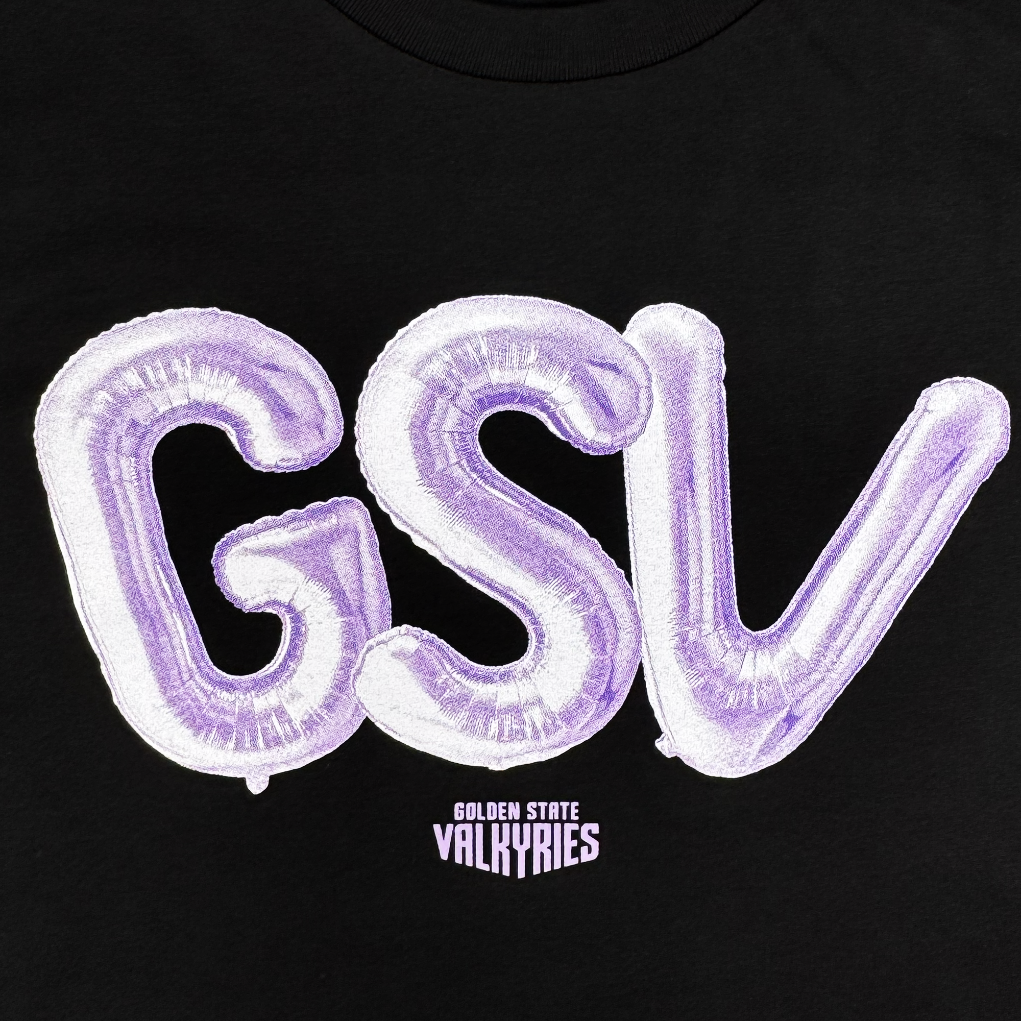 The Golden State Valkyries Balloons LS Tee by GSV features large, metallic purple balloon letters spelling “GSV” on a black cotton background above “GOLDEN STATE VALKYRIES,” creating a bold and festive look.