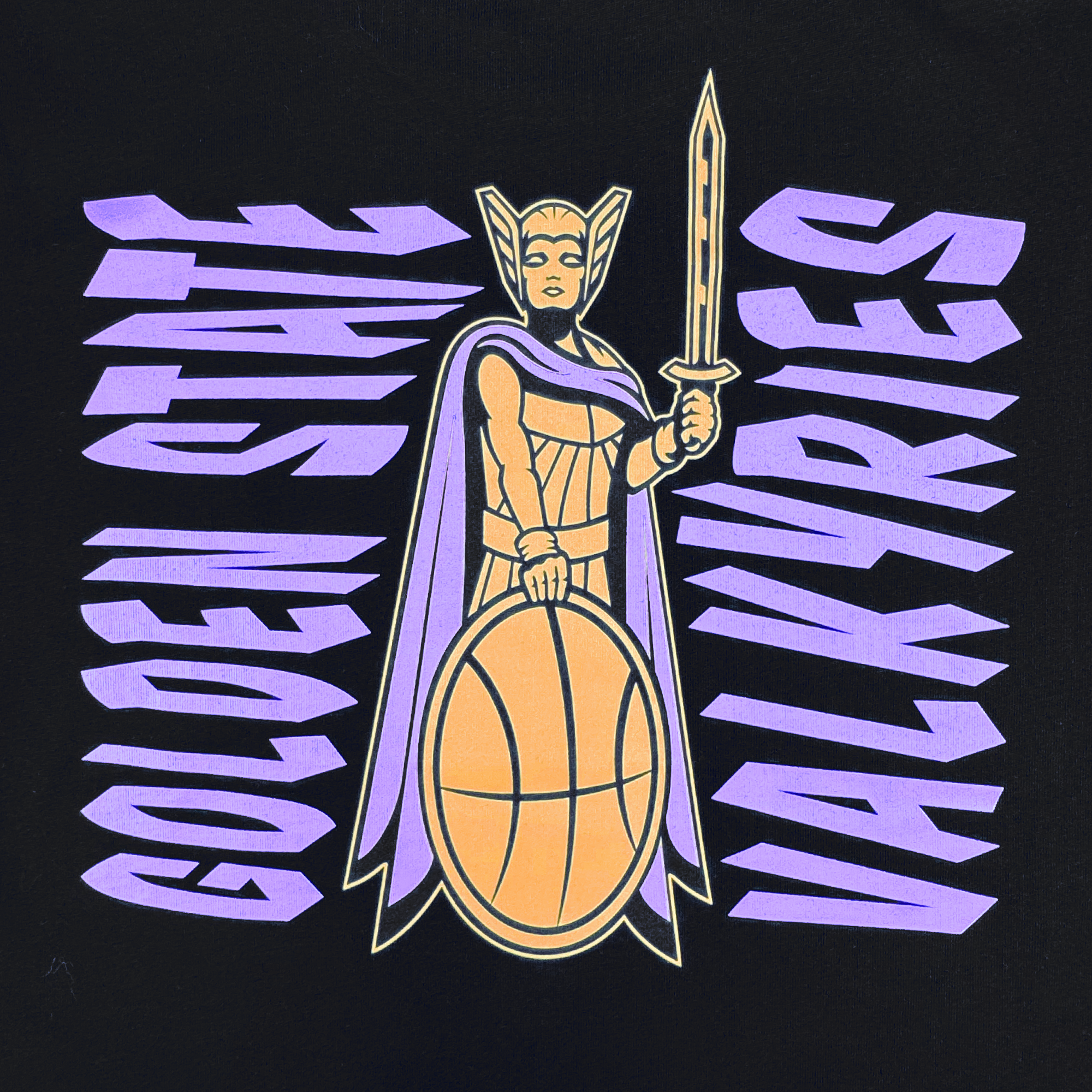A warrior woman in a winged helmet and cape holds a sword and basketball shield. Bold purple "GOLDEN STATE VALKYRIES" text on black makes this GSV Golden State Valkyries Renowned Heavy Tee perfect for comic book fans.