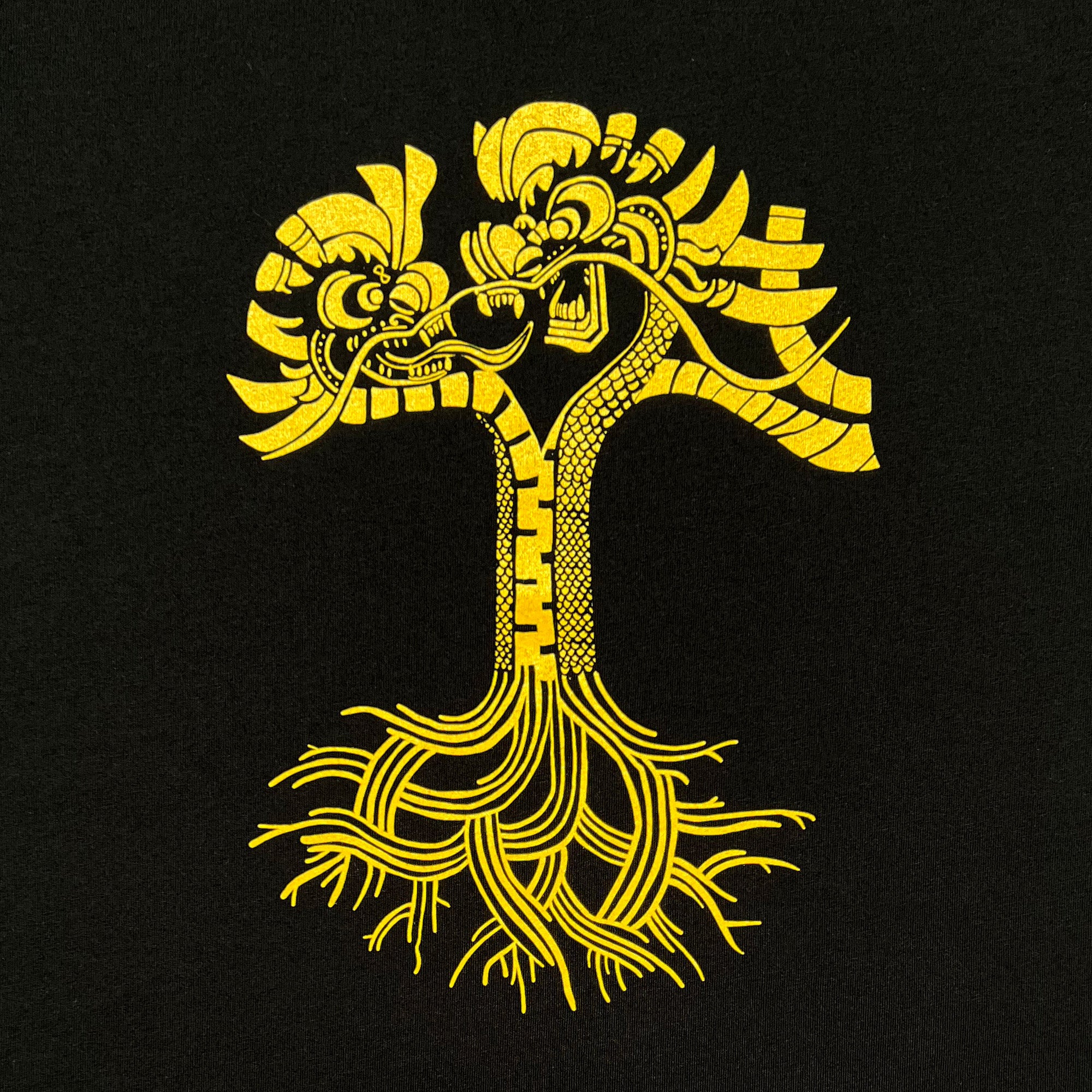 The Dragon Power Tee by Oaklandish features an intricate yellow graphic on a black background. It portrays a tree whose trunk and branches are formed by dragons' heads and necks, symbolizing the rich cultural heritage of Oakland Chinatown. The stylized roots extend in various directions, while the dragons face each other, showcasing their detailed scales and ornate features.