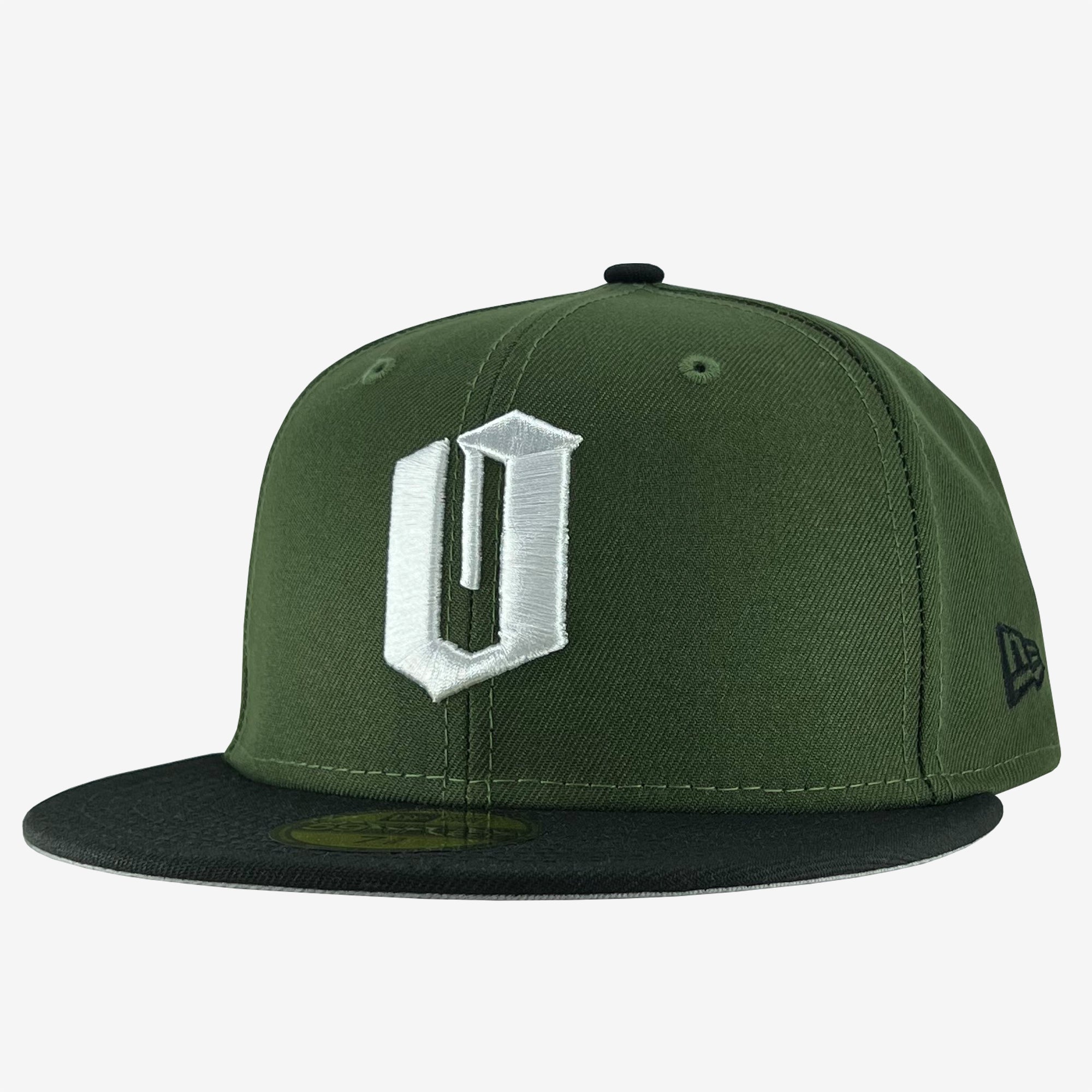 A green New Era Official 59FIFTY Fitted Cap from Oaklandish, featuring a dark green flat brim with an embroidered white "U" on the front panel. The cap's authenticity is unmistakable, as indicated by the sticker on the brim and the "New Era" logo on the left side.