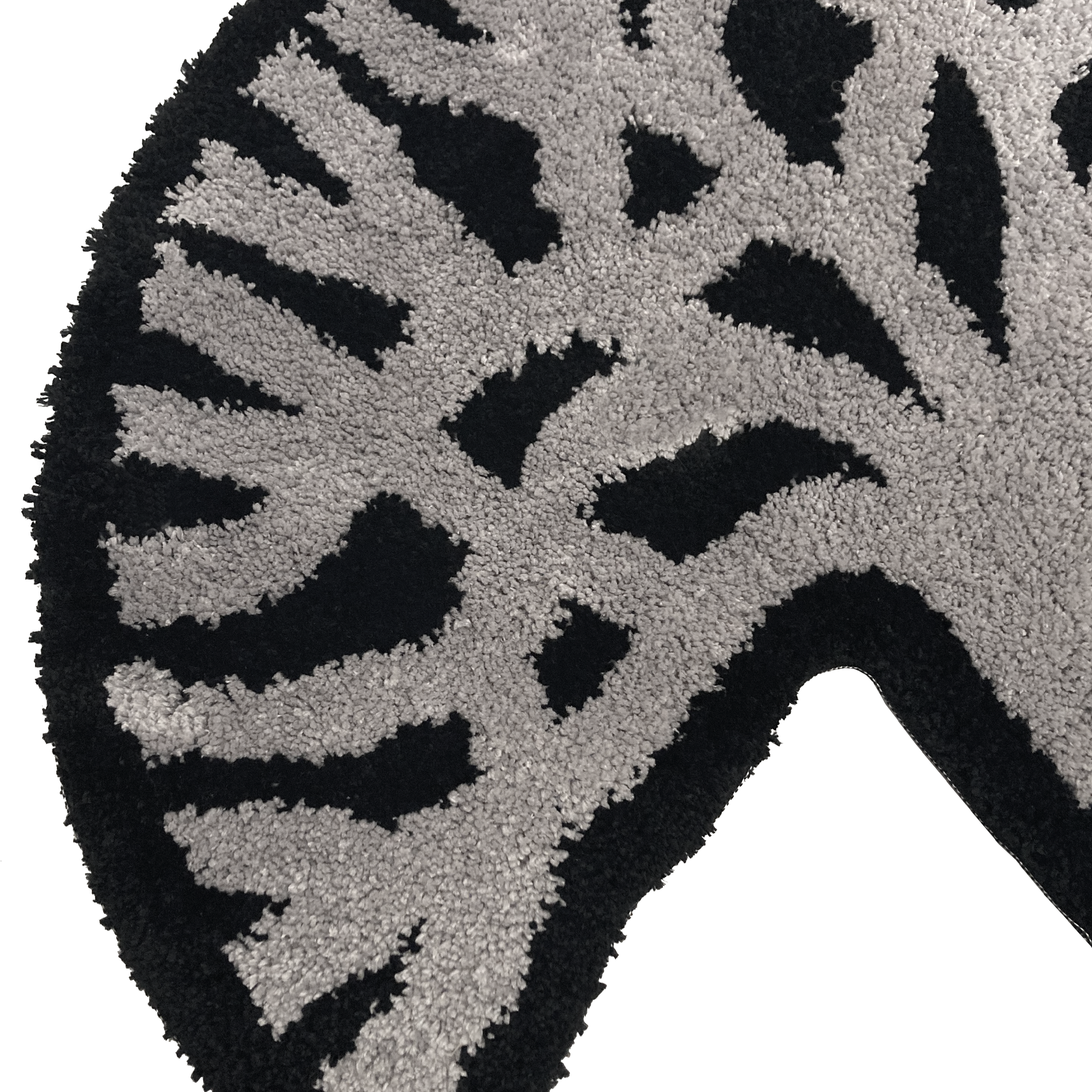 A close-up view of the Oaklandish Logo Rug by Oaklandish, showcasing a curved design with an abstract geometric pattern. The motif features light gray and black sections, creating a dynamic, asymmetrical appearance. The texture appears soft and plush, adding depth and visual interest to the Oaklandish-inspired design.