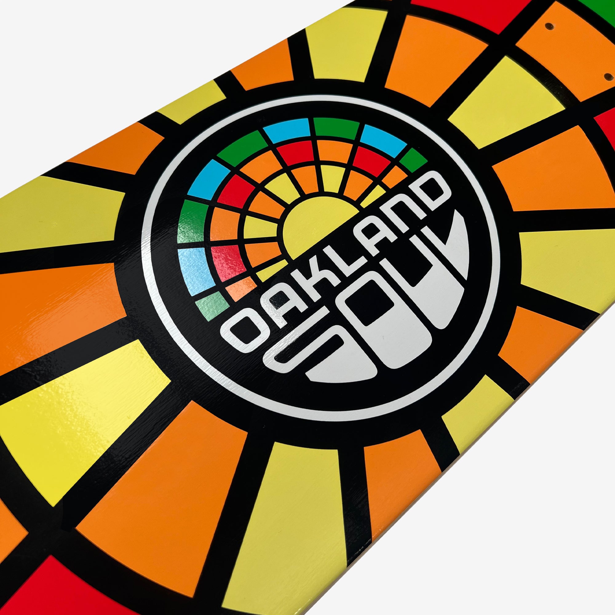 Close-up of the Oakland Soul Logo Skate Deck, made from 7-ply maple wood and showcasing a vibrant geometric design. The pattern features a colorful sunburst-like motif with yellow, orange, red, green, and blue segments radiating from the center. The text "Oakland Soul" is prominently placed in the middle of the design.