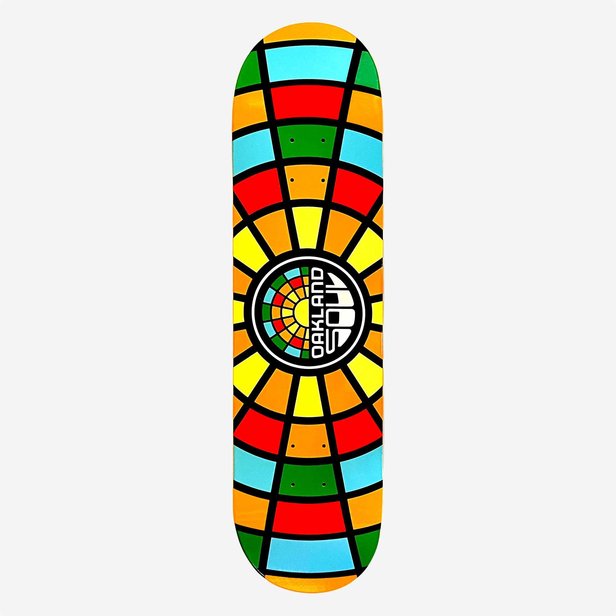 The Oakland Soul Logo Skate Deck is made from 7-ply maple wood and boasts a vibrant, colorful design featuring geometric patterns in red, yellow, green, and blue. The design resembles a stained-glass window with black lines dividing the colors into sections. The center of the deck features a circular pattern with "OAKLAND SOUL SC" written within.