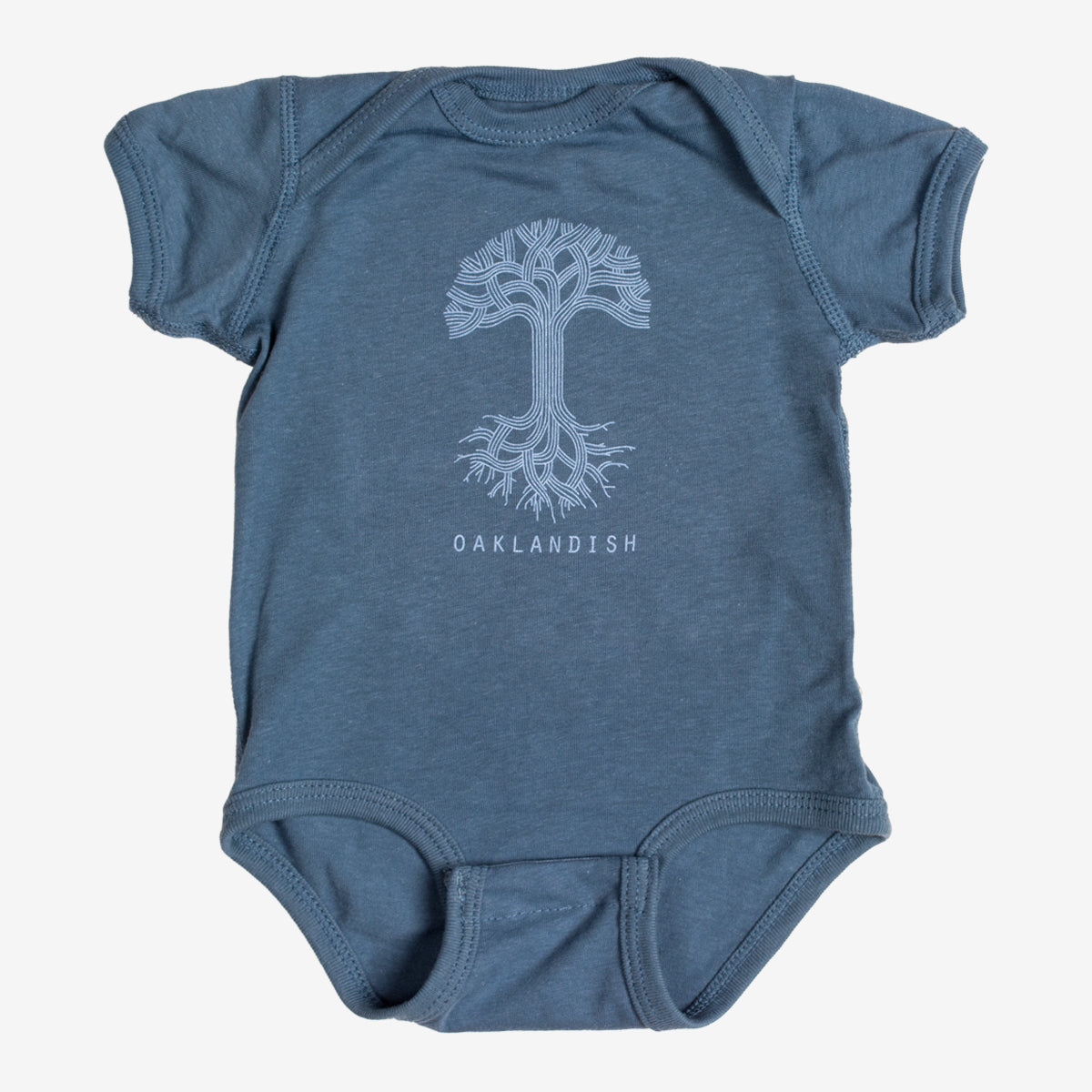 This Infant Oaklandish Classic Logo One-Piece by Oaklandish is a blue baby romper crafted from soft cotton. It features a white graphic of an intricately designed tree with symmetrical roots and branches, along with "OAKLANDISH" printed in white capital letters below the tree. The kids' onesie comes with short sleeves and leg openings that include snap closures.