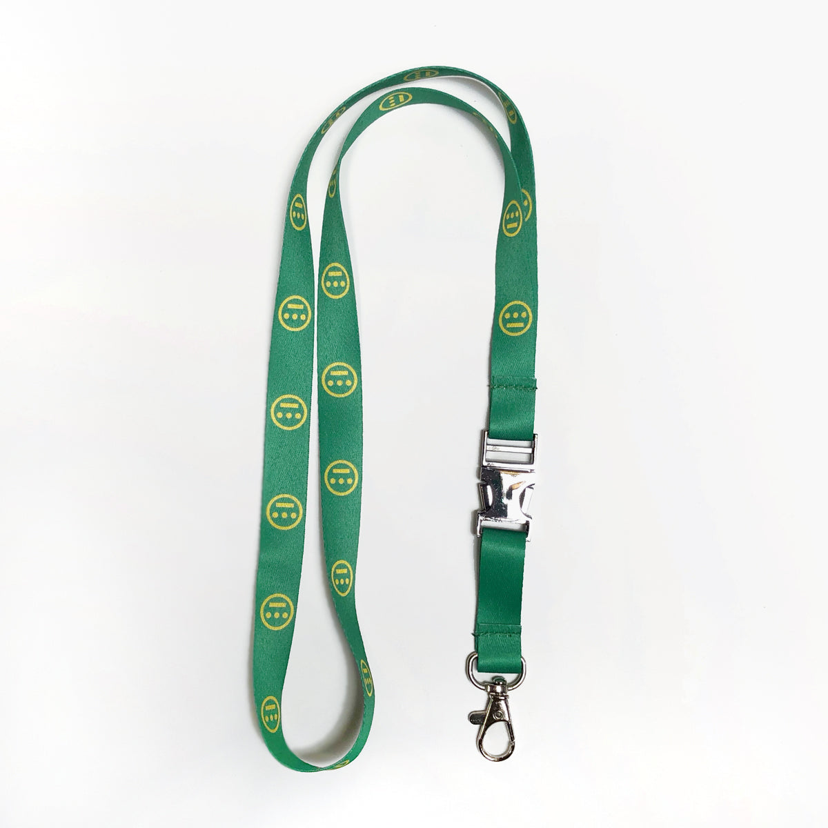 The Hieroglyphics Hiero VIP Lanyard features a vibrant green design adorned with yellow smiley face patterns. It comes equipped with a silver clasp and buckle, as well as a metal swivel hook for easy attachment of your key chain. The plain white background highlights the lanyard’s striking appearance.