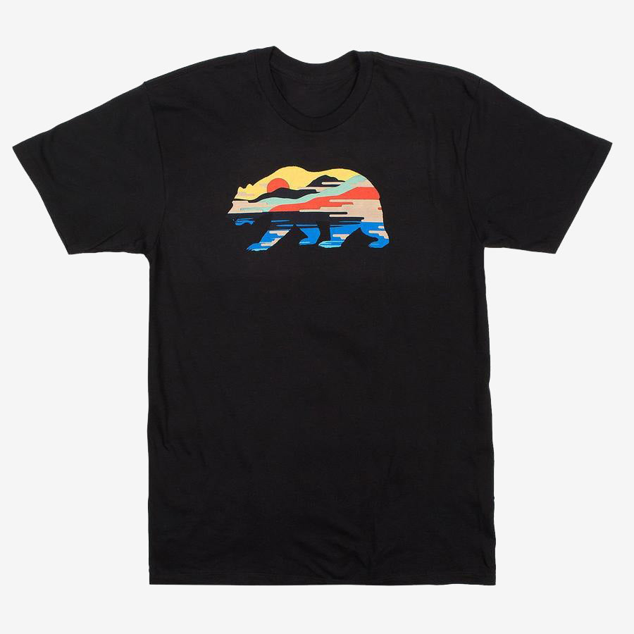 The Sunset Bear Full T-shirt from Never Elsewhere is a black, 100% cotton shirt featuring a stylized design of a California grizzly silhouette filled with a colorful landscape. Inside the bear shape, a red sun, mountains, trees, and blue water are depicted in a horizontal stripe pattern. This T-shirt has short sleeves and a round neck.