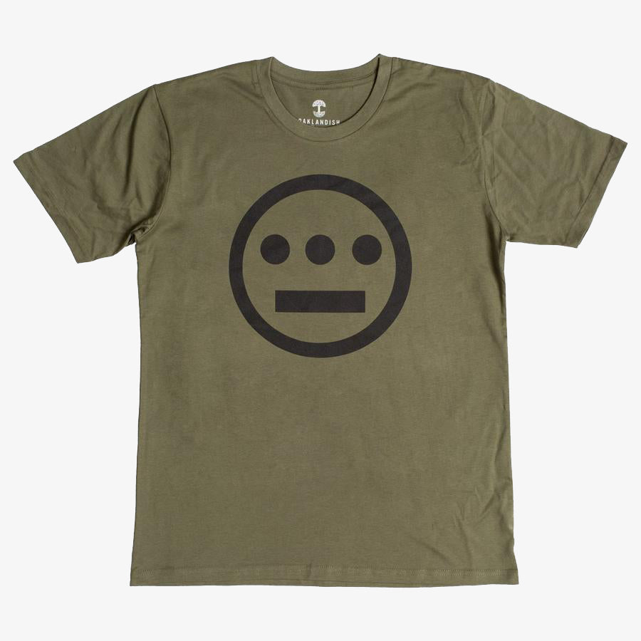 The Hiero Classic Logo Tee by Hieroglyphics is an olive green, classic fit T-shirt made from 100% cotton. It features a black logo centered on the chest, which is a simple geometric design resembling hieroglyphics. The logo consists of a circle with three dots forming a horizontal line and a straight line beneath them. The shirt has a crew neckline.