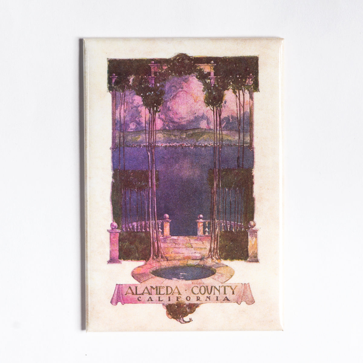 A vintage illustration of a gazebo overlooking a body of water with mountains in the background. Tall, slender trees frame the view. Below the illustration, a banner reads "Alameda County, California." The scene is rendered in muted tones with a slightly faded appearance—perfect for an Alameda County Magnet by Oaklandish.
