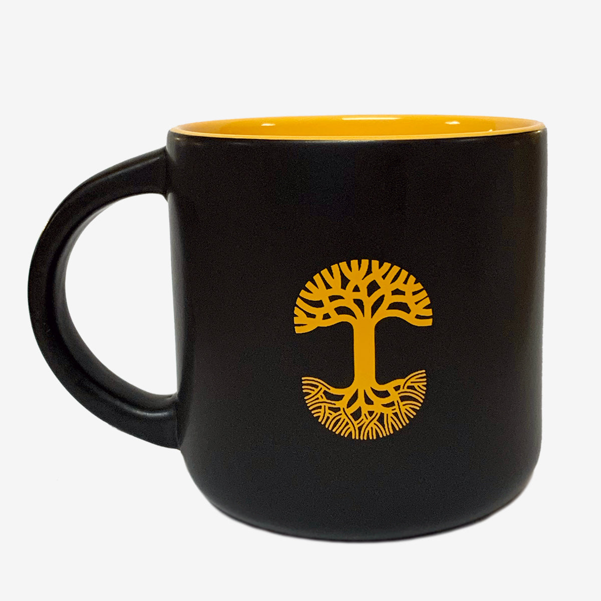 The Sunny Side Mug by Oaklandish is a black ceramic bay mug featuring a glossy yellow interior. Adorning the side is a yellow tree design with branches and roots forming a circular emblem. This stoneware mug boasts a wide handle and a smooth, glossy finish.