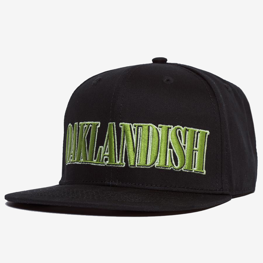 Introducing the Greenback Snapback by Oaklandish: a stylish black cap with a flat brim, featuring "OAKLANDISH" embroidered in large green letters across the front. This trendy piece of headwear is showcased against a plain white background.