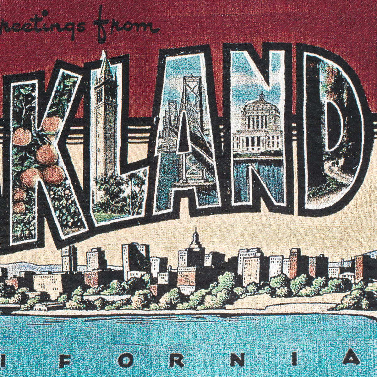 The "Greetings From Oakland Throw" by Oaklandish is a vintage postcard-inspired piece, showcasing bold, colorful letters that each feature local landmarks like a clock tower, bridge, and domed building. The foreground reveals a city skyline and waterfront framed by orange-red, green, and blue hues. This eco-friendly throw is crafted with recycled fibers.