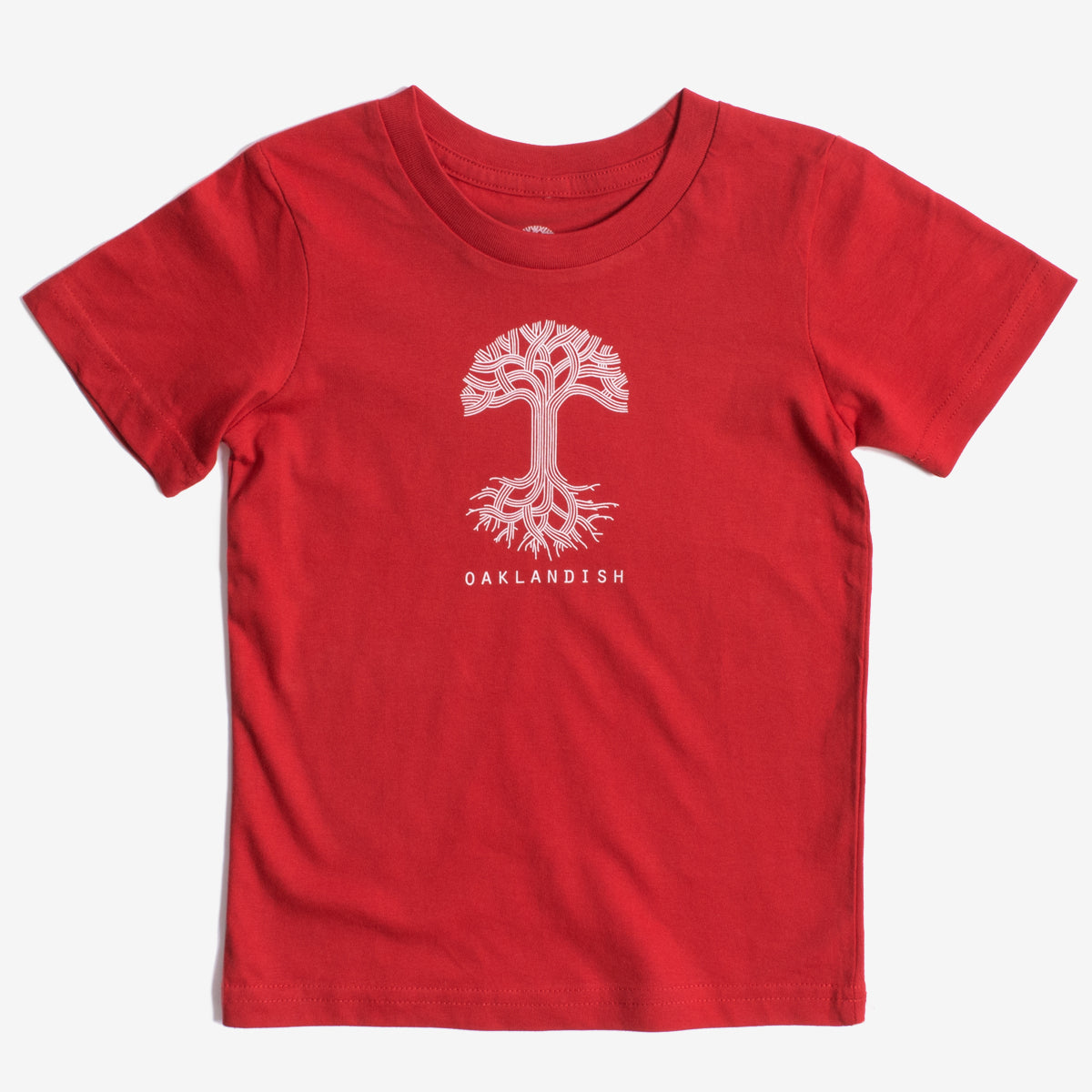 The Toddler Oaklandish Classic Logo Tee by Oaklandish features a red, short-sleeve T-shirt made from 100% cotton. It has a white graphic of a stylized tree with sprawling roots and branches, with "OAKLANDISH" printed in bold white capital letters below the tree. The shirt is displayed laid flat against a white background.